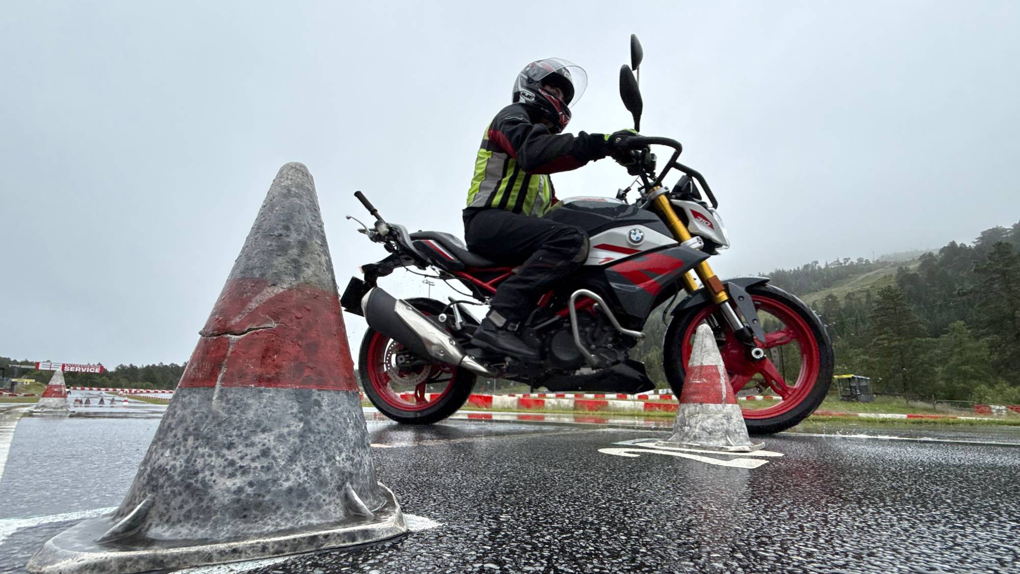 mann på motorsykkel på våt asfalt 