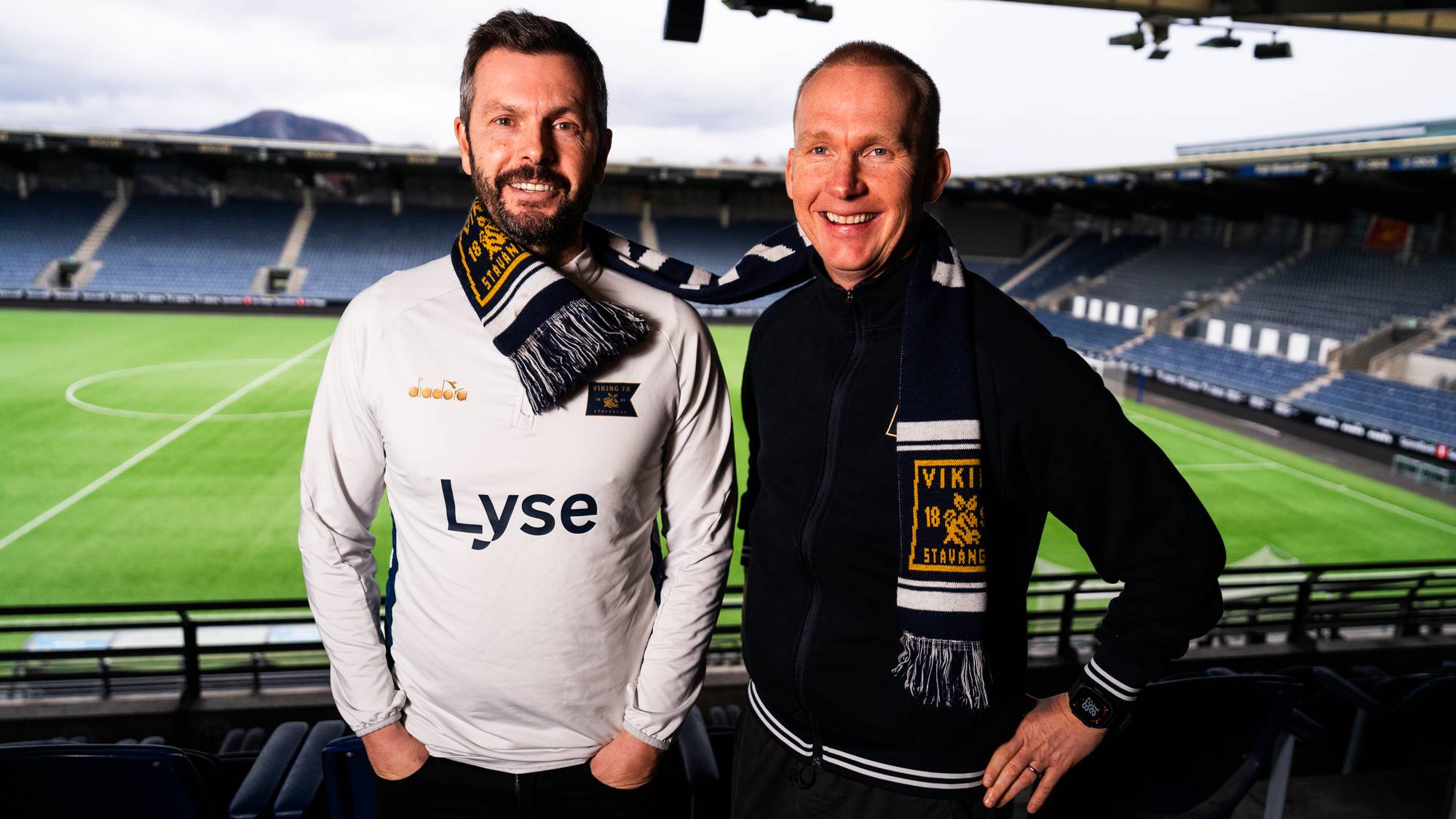 et par menn som poserer for et bilde på en idrettsplass