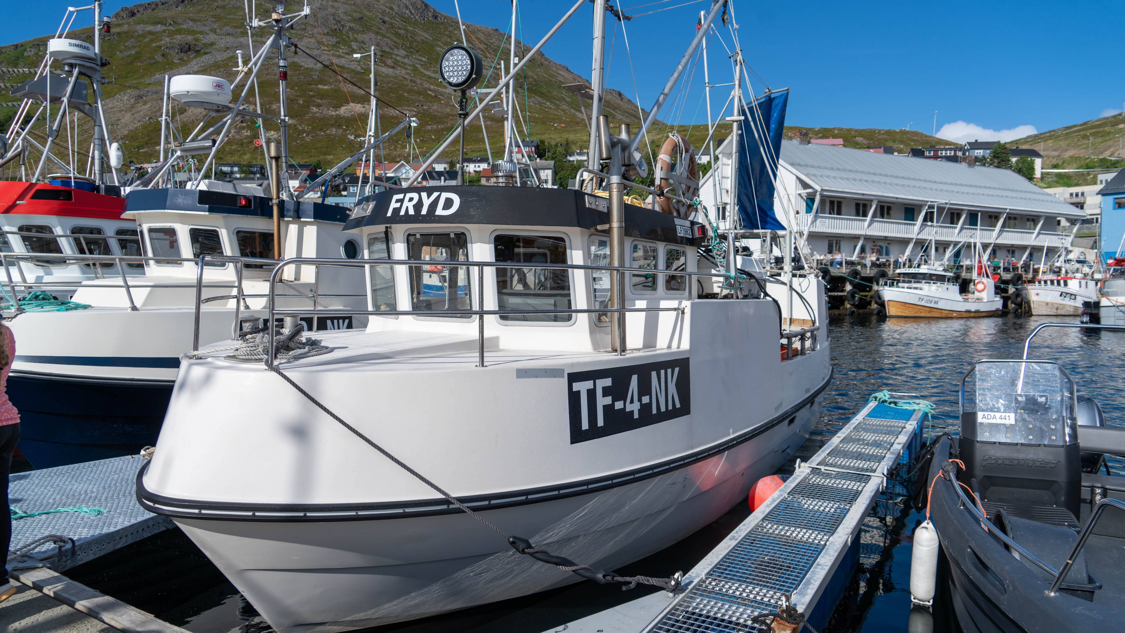Fiskebåt ligger fortøyd ved en kai i en småbåthavn.