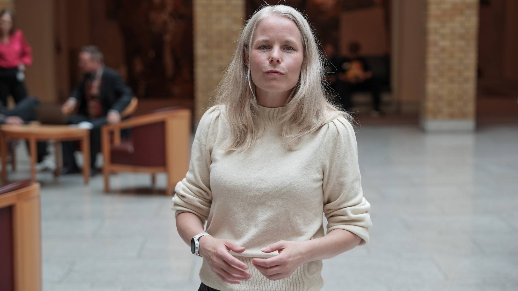 En kvinne ser i kamera inne i en bygning. 