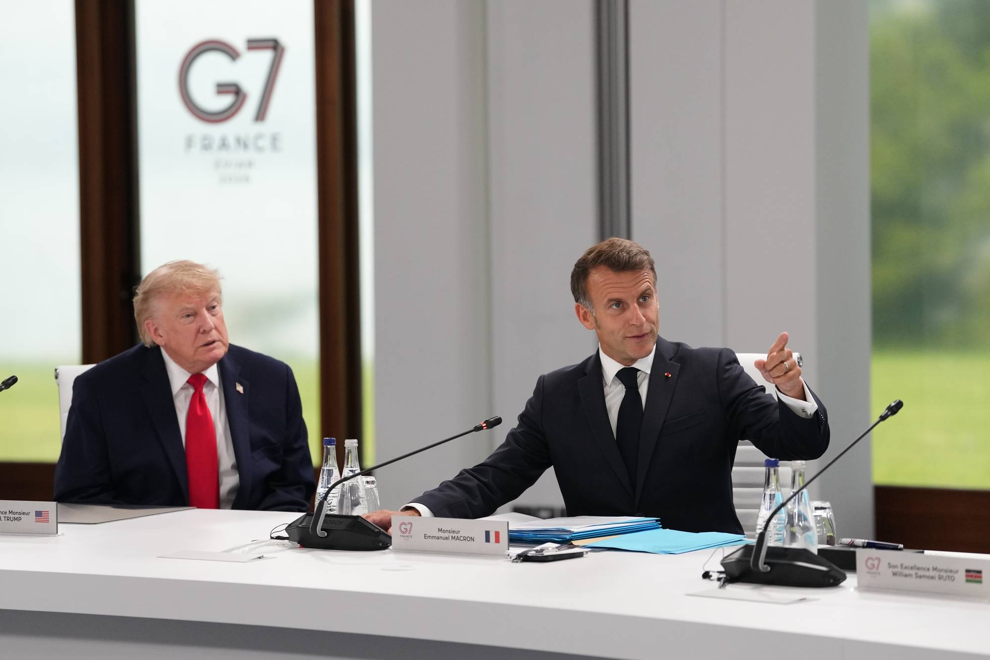 Trump og Macron ved et bord.
