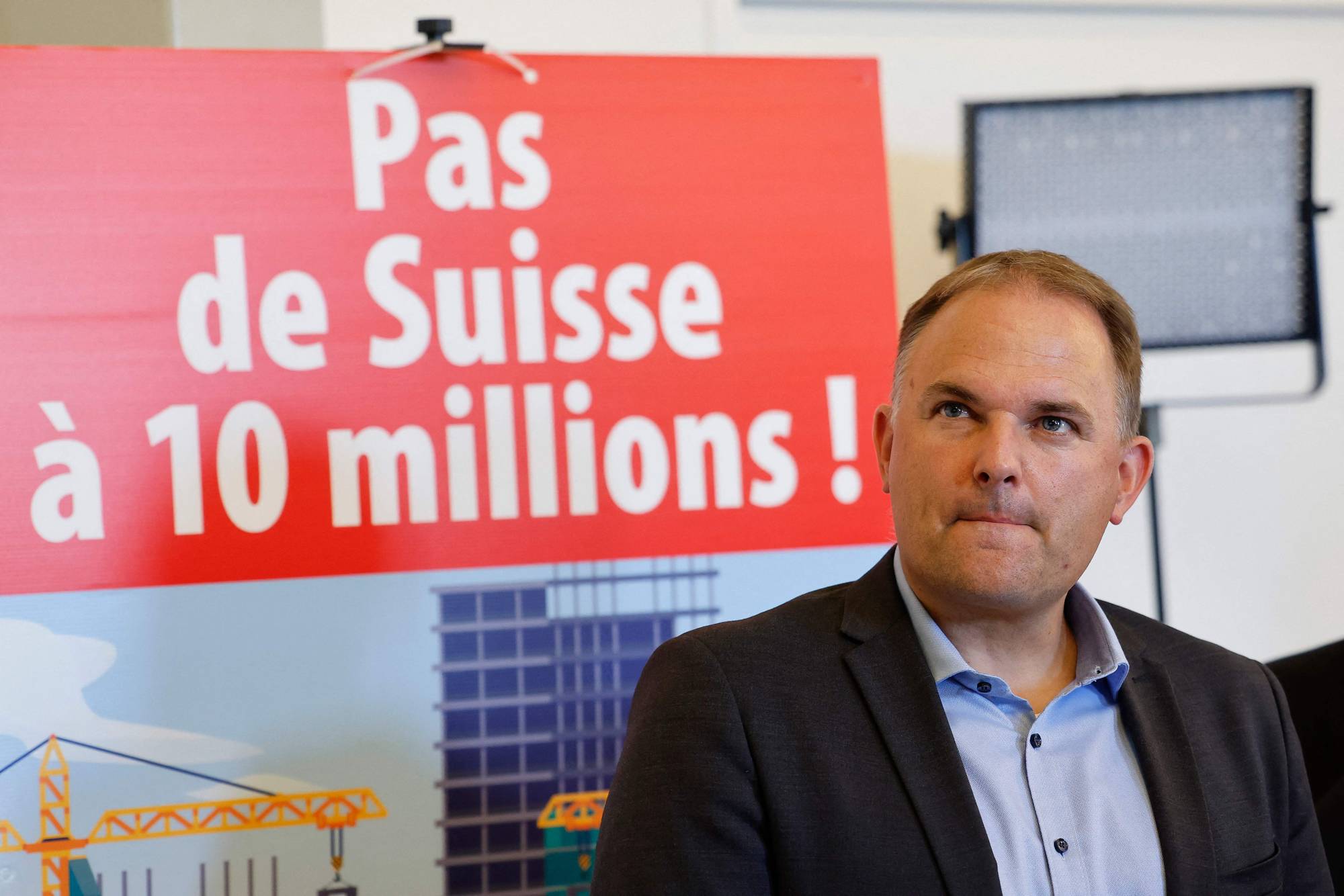 Leder av Folkepartiet (SVP) i Sveits med en plakat som fremmer forslaget om å hindre befolkningsveksten. 