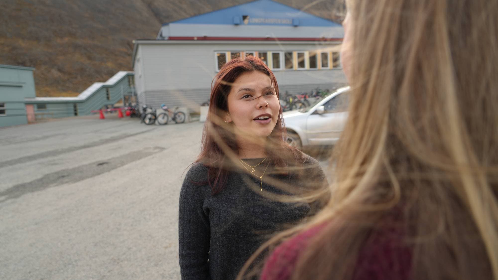 En kvinne ser på en annen kvinne som står med ryggen til. 