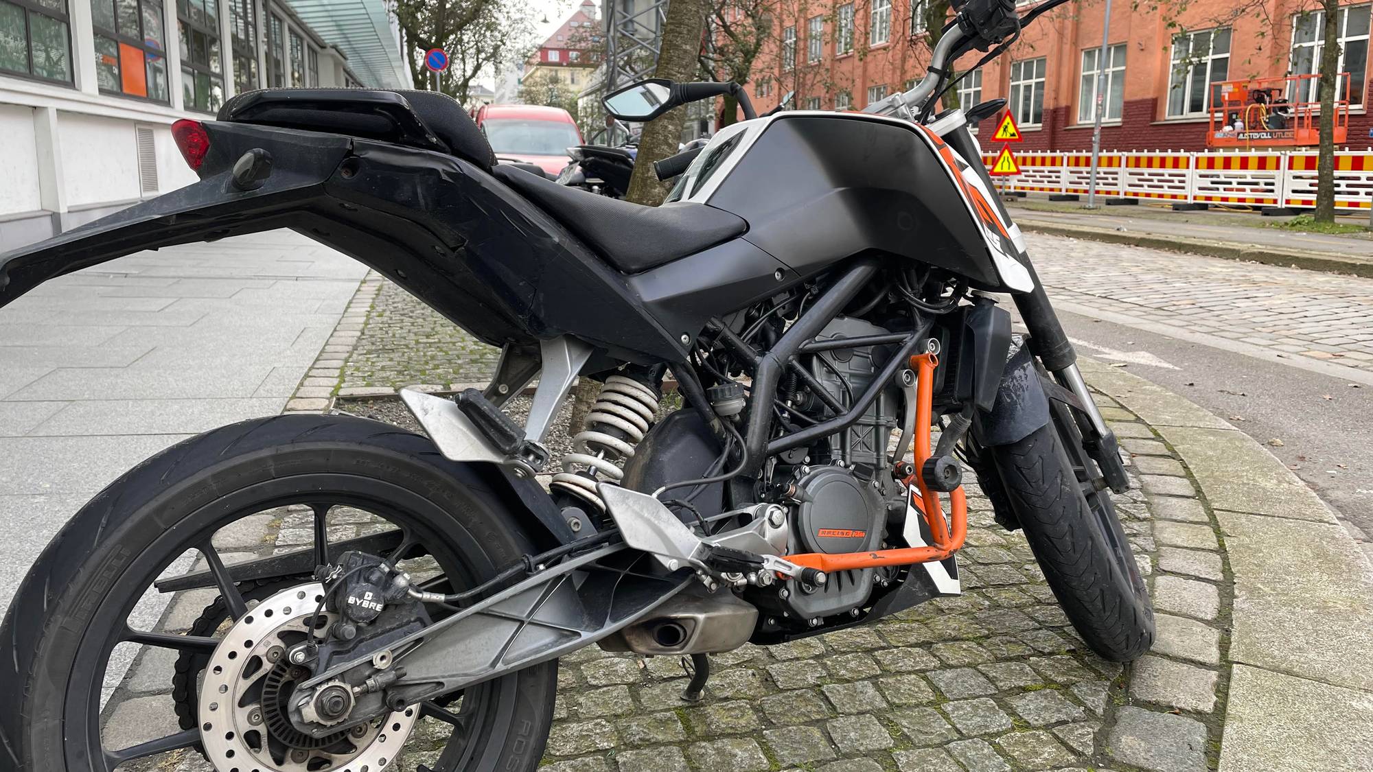 Ein lett motorsykkel som står parkert på eit fortau i Bergen
