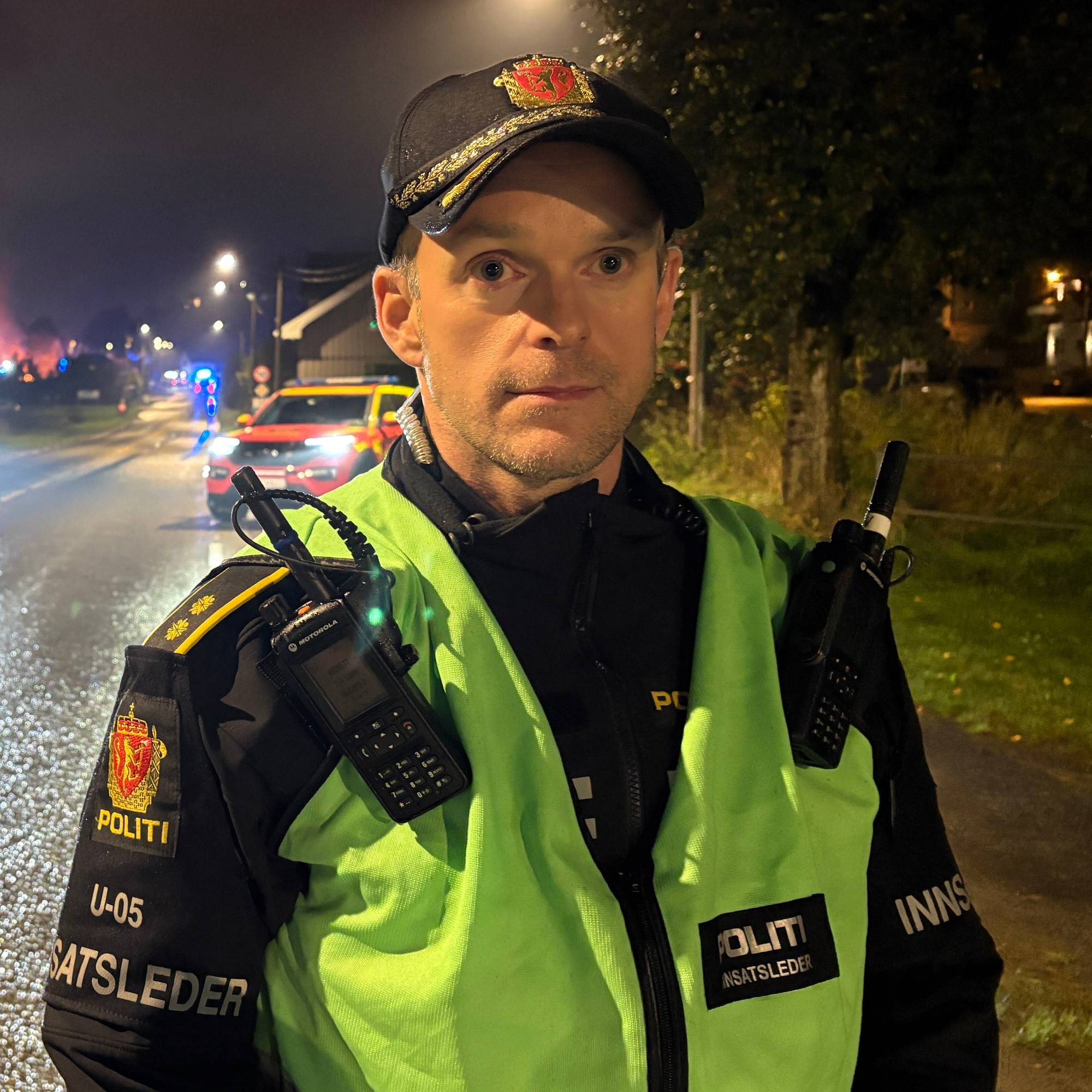 En uniformert politimann står på en vei.
