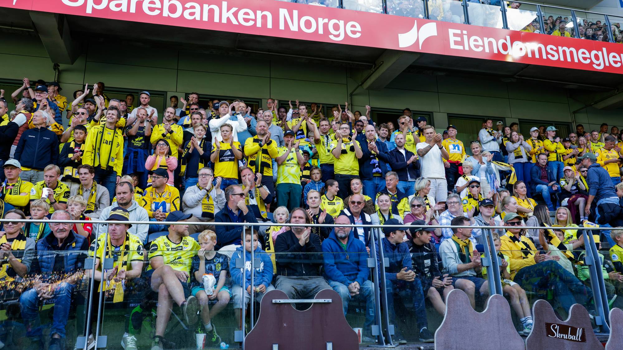 viser flere mennesker i drakter på en stadion