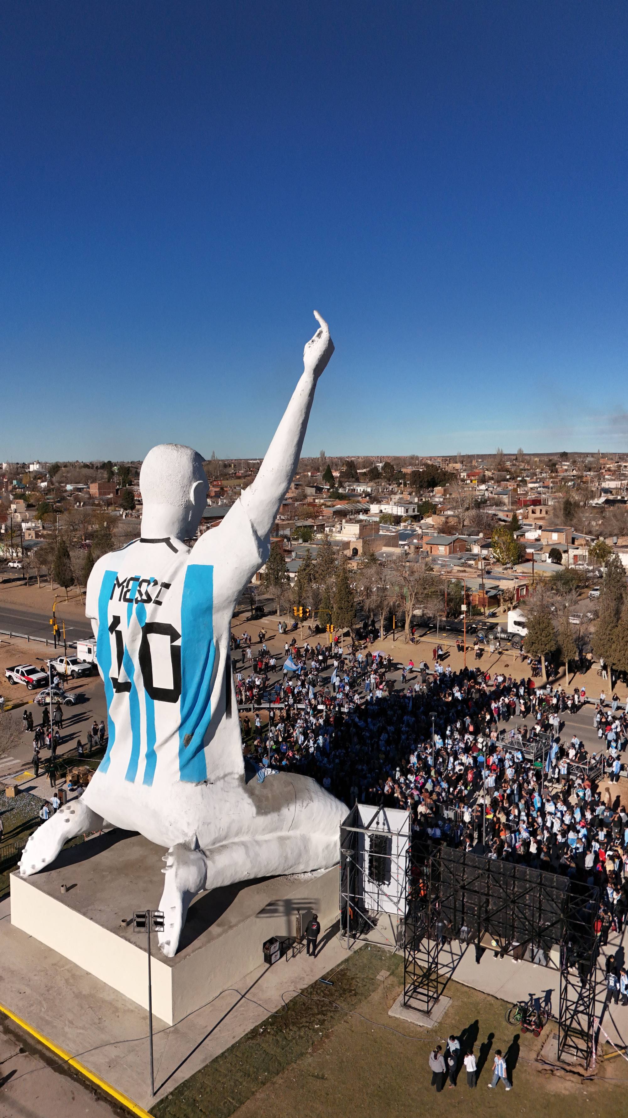 En stor statue av Lionel Messi sett bakfra med en folkemengde foran i Argentina. (Bildebeskrivelsen er laget av en KI-tjeneste)