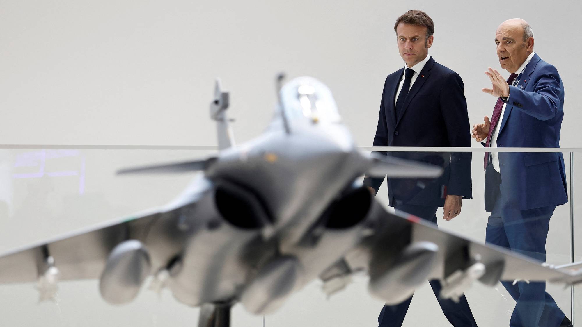 Frankrikes president Emmanuel Macron blir vist en modell av det franske kampflyet Rafale av Dassault-sjef Eric Trappier under flyshow i Paris juni 2025.