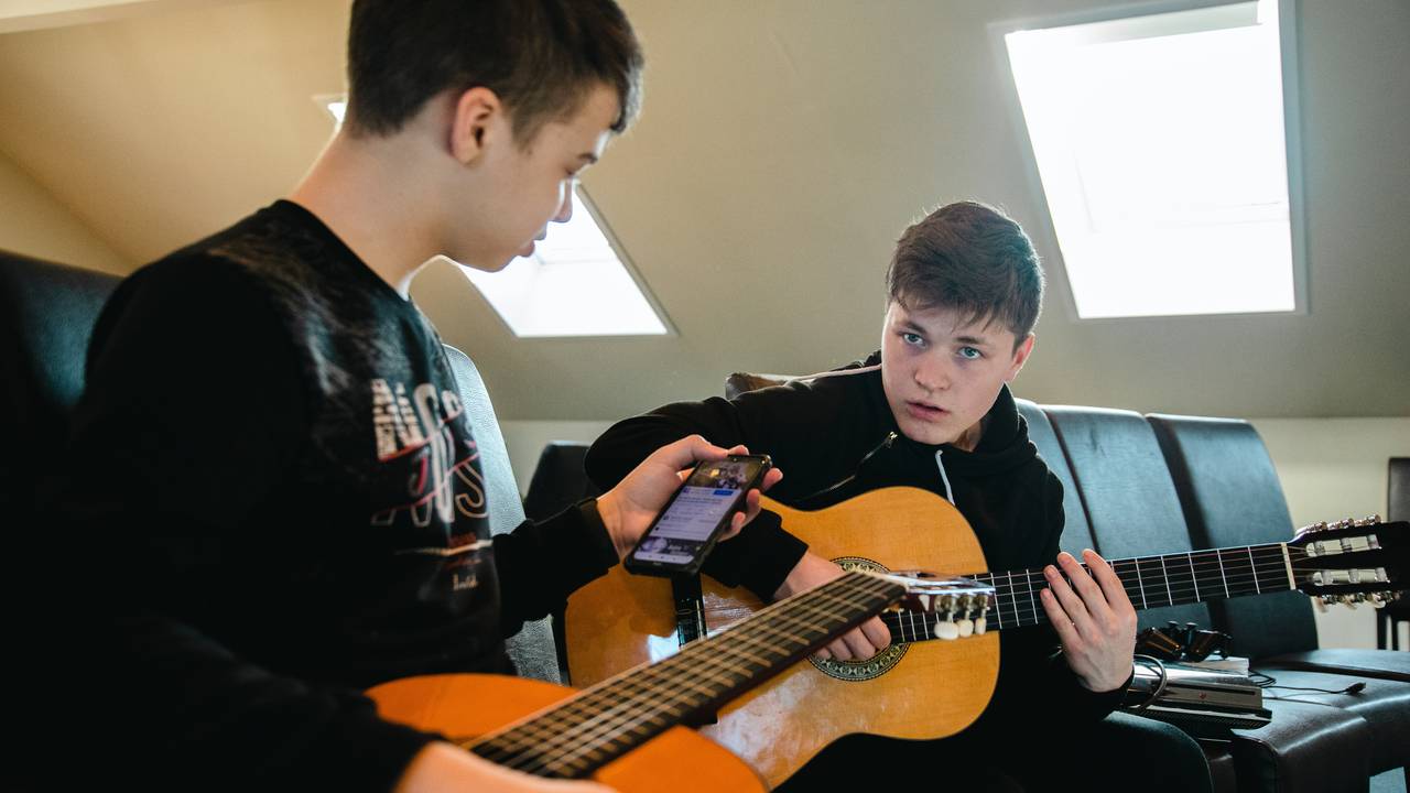 Sasha Vititnov (14) (til venstre) og Valentin Stopkin (17) prøver å lære seg ein ny song på gitar.