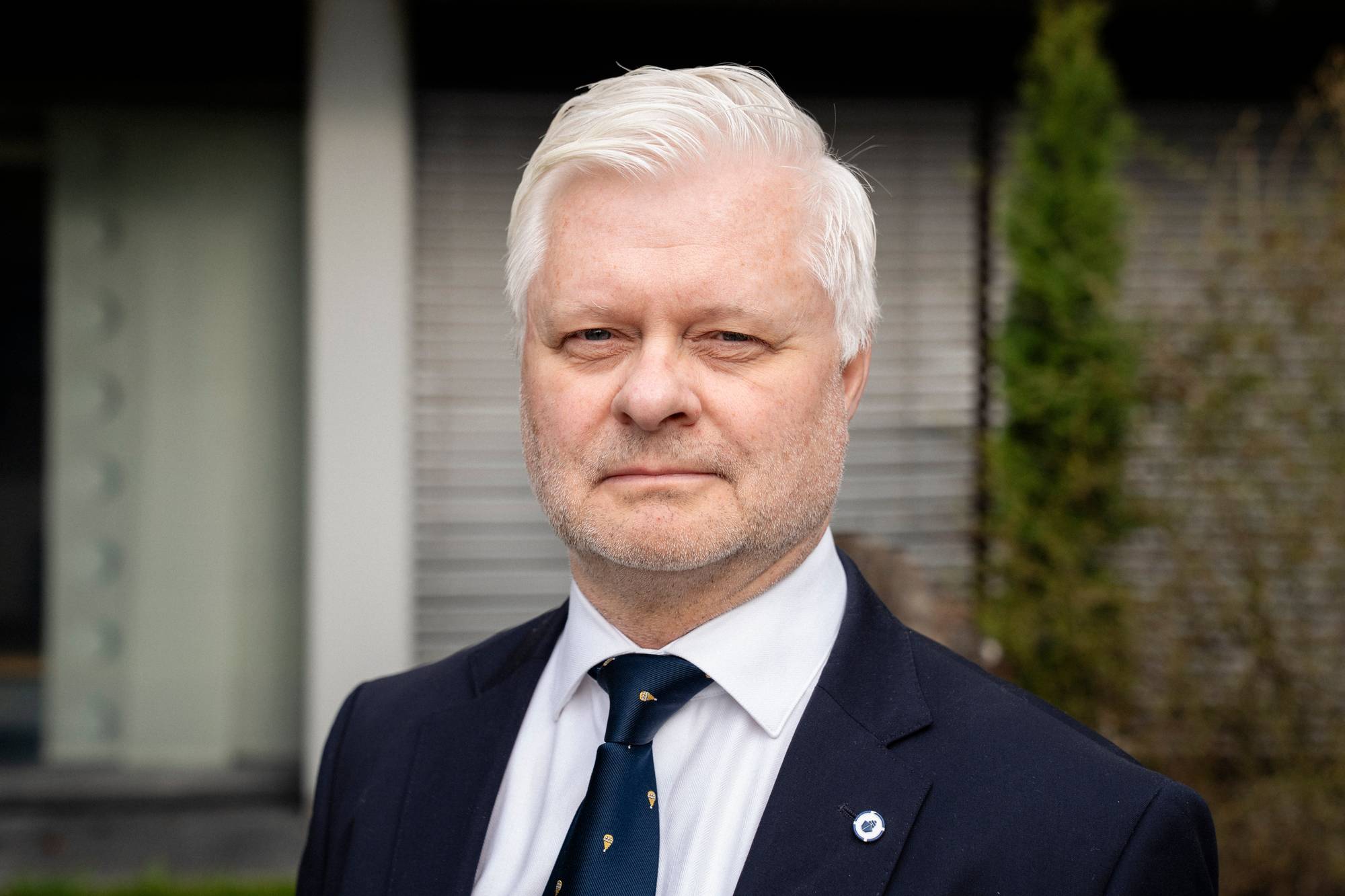 En mann i mørk dress poserer for kamera.