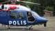 Bjarte M. Johannesen / NRK Politibetjent i et svensk politihelikopter på bakken ved en skog. (Bildebeskrivelsen er laget av en KI-tjeneste)