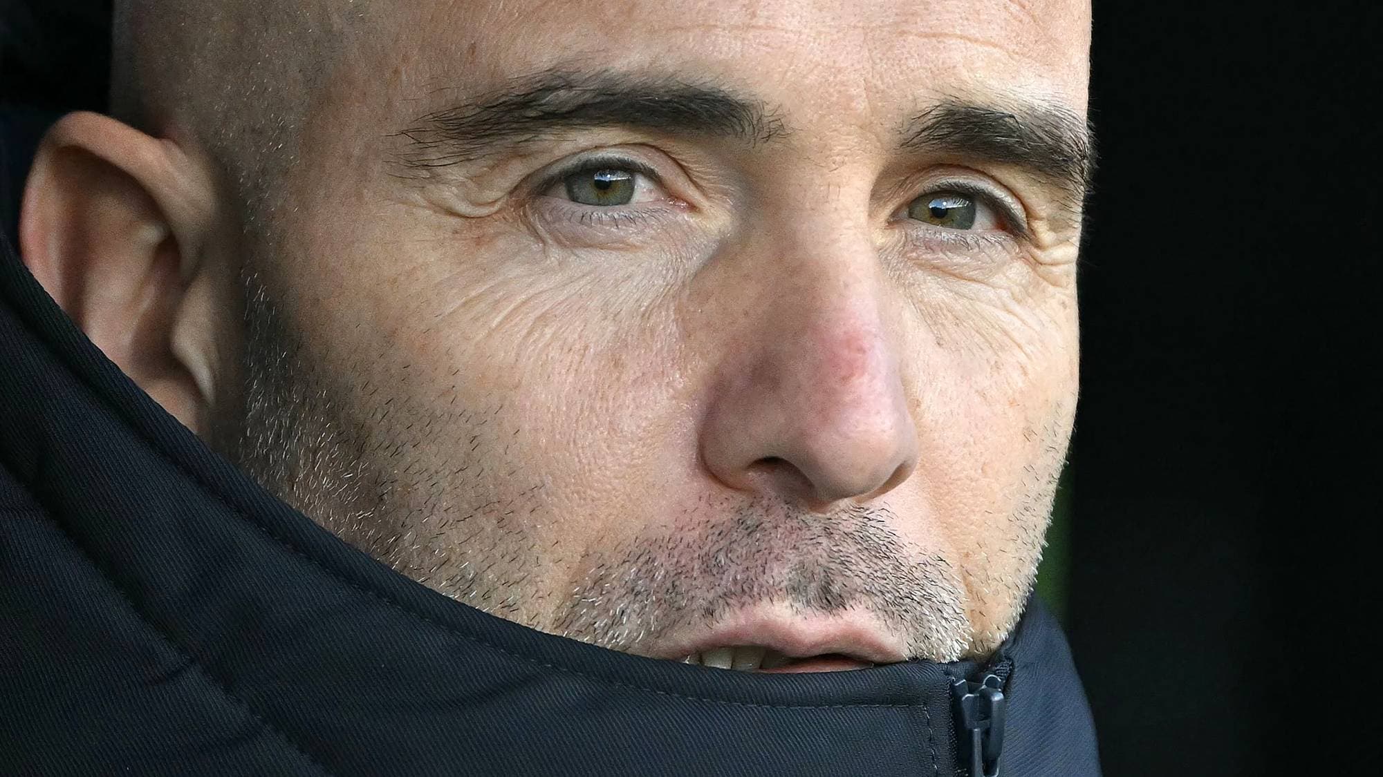 Nærbilde av fotballtrener som ser mot siden. (Bildebeskrivelsen er laget av en KI-tjeneste)