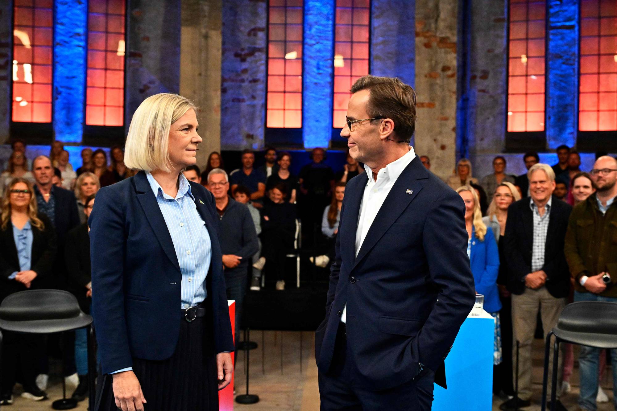 Magdalena Andersson og Ulf Kristersson står på en scene foran et publikum. (Bildebeskrivelsen er laget av en KI-tjeneste)