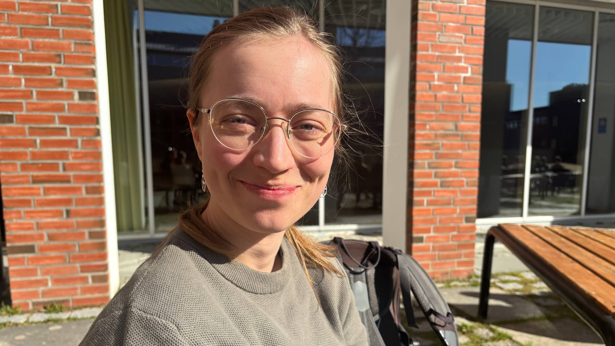 Ane Margrethe Ugelvik, ei kvinne med briller som sit på ein benk og smiler