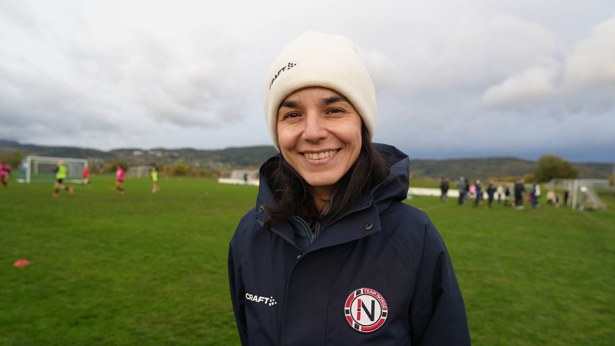 Kvinne på fotballbane med lue