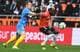 FRED TANNEAU / AFP,NTB To fotballspillere i aksjon. En spiller i blå drakt med gult bånd i håret utfordrer en spiller i oransje drakt som dribler ballen. Bakgrunnen viser et publikum på tribunen. (Bildebeskrivelsen er laget av en KI-tjeneste)