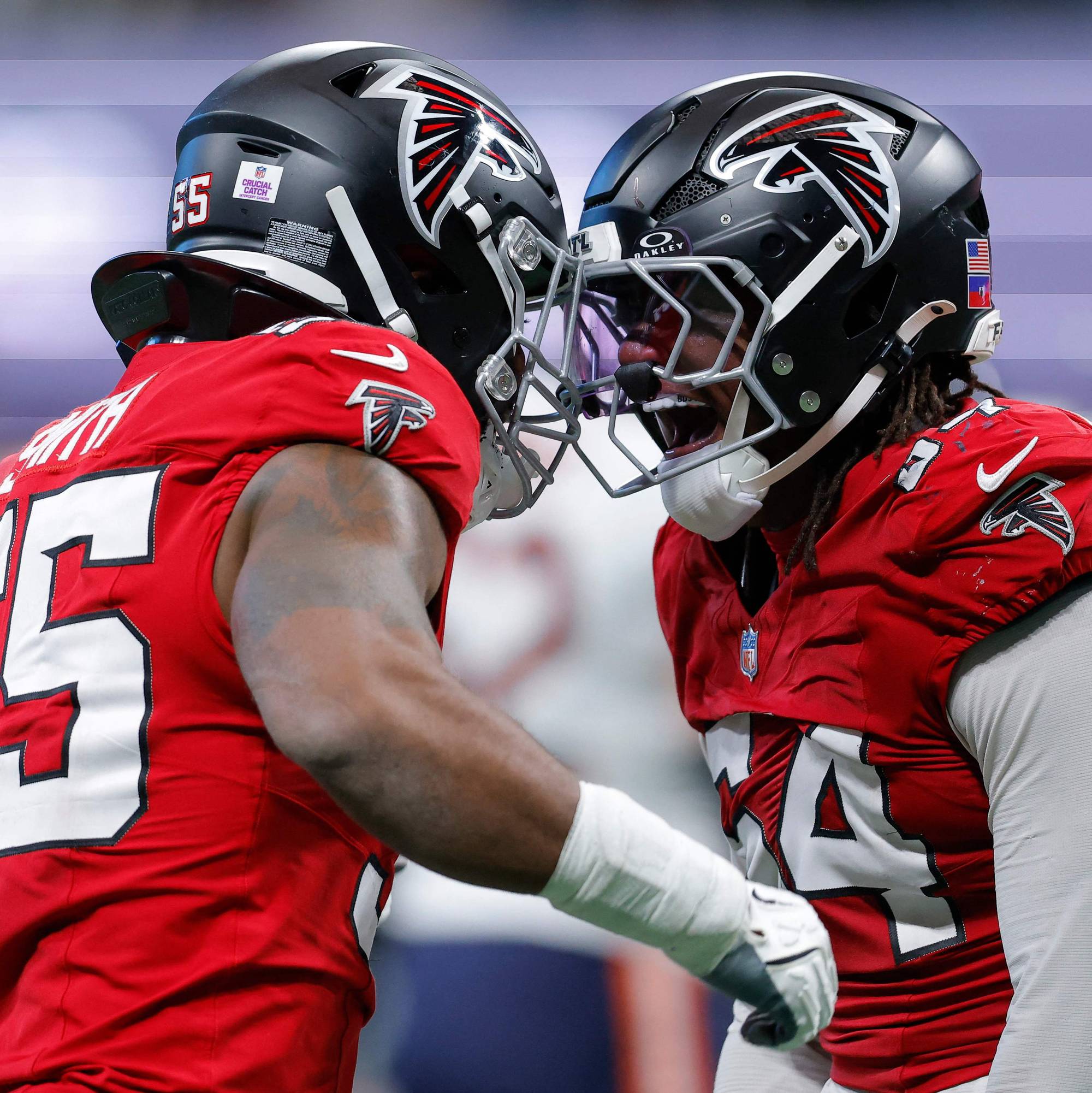 To amerikanske fotballspillere fra Atlanta Falcons feirer sammen på banen. (Bildebeskrivelsen er laget av en KI-tjeneste)
