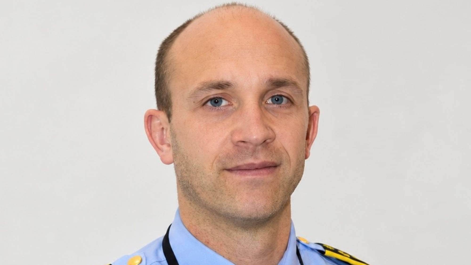Politimann i blå skjorte og svart slips