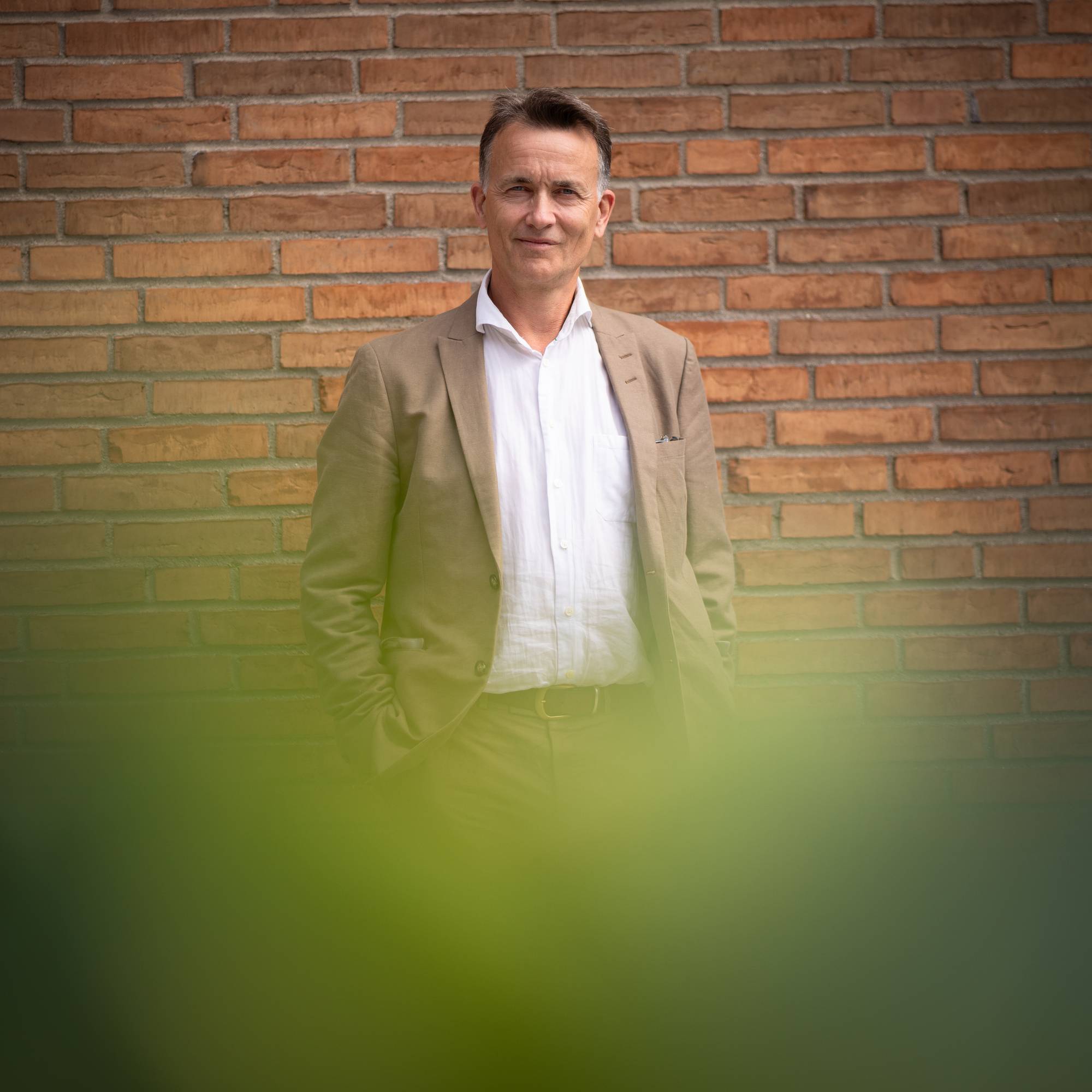 En mann med brun dress og kort hår.