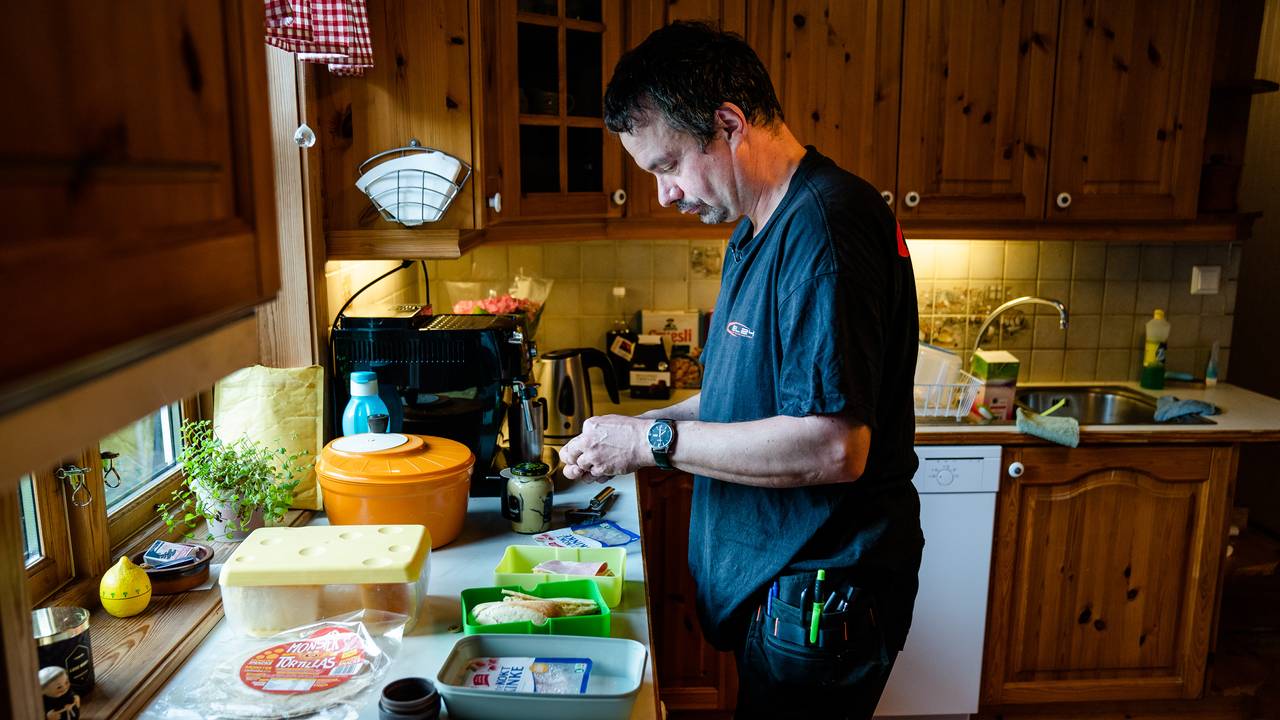 Carolus fikser seg matpakke på kjøkkenet før jobb.