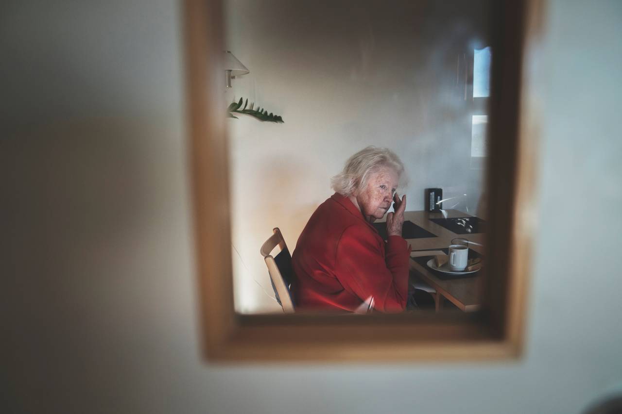 Anne Marie sitter ved frokostbordet og stirrer ut i rommet mens hånden strekkes opp til øynene.