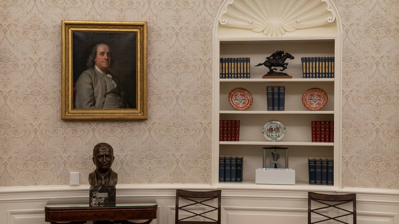 Det ovale kontor i Det hvite hus under Joe Biden. En byste av president Harry Truman står under et portrett av Benjamin Franklin. I bokhyllen står en stein fra månen (midten nederst).