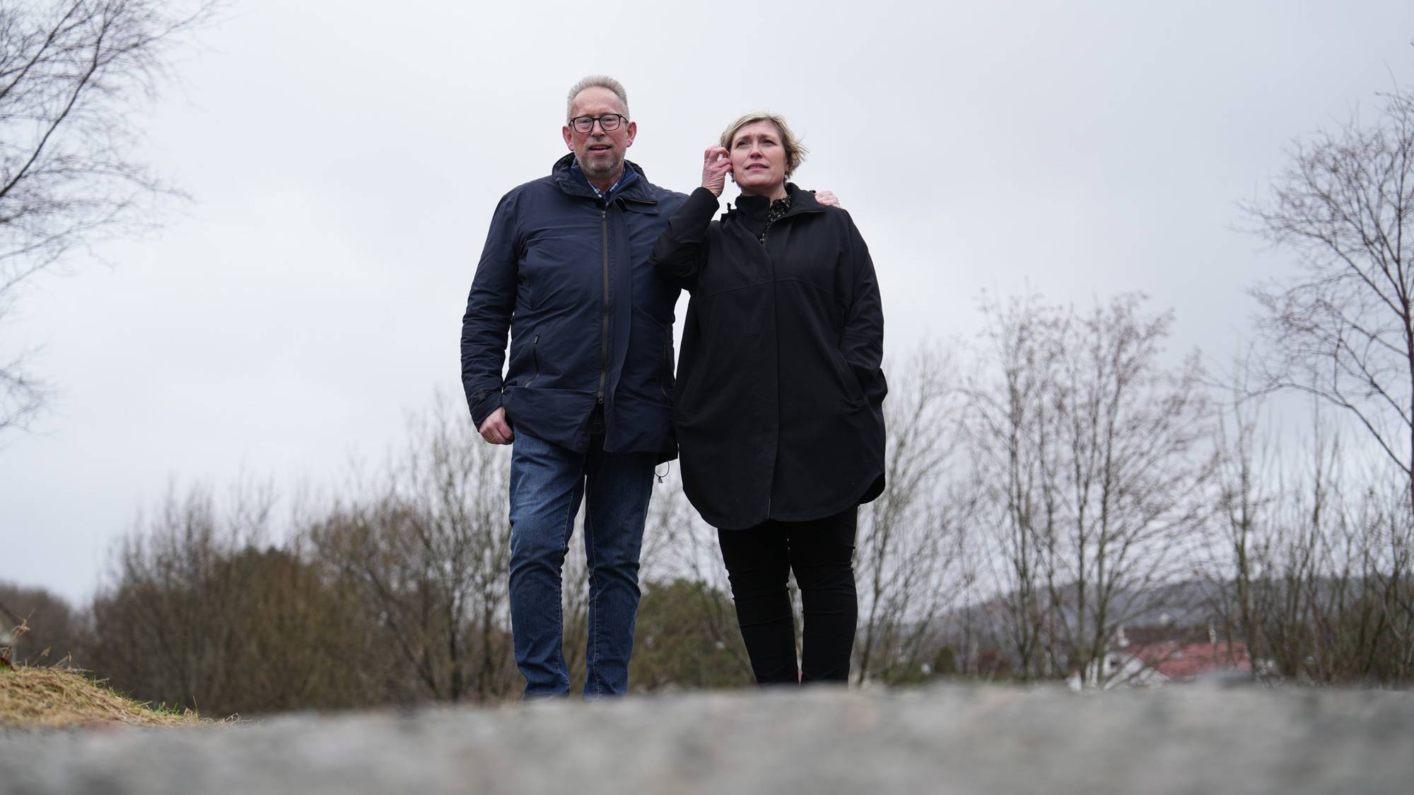 Ektepar går tur rundt et vann. 