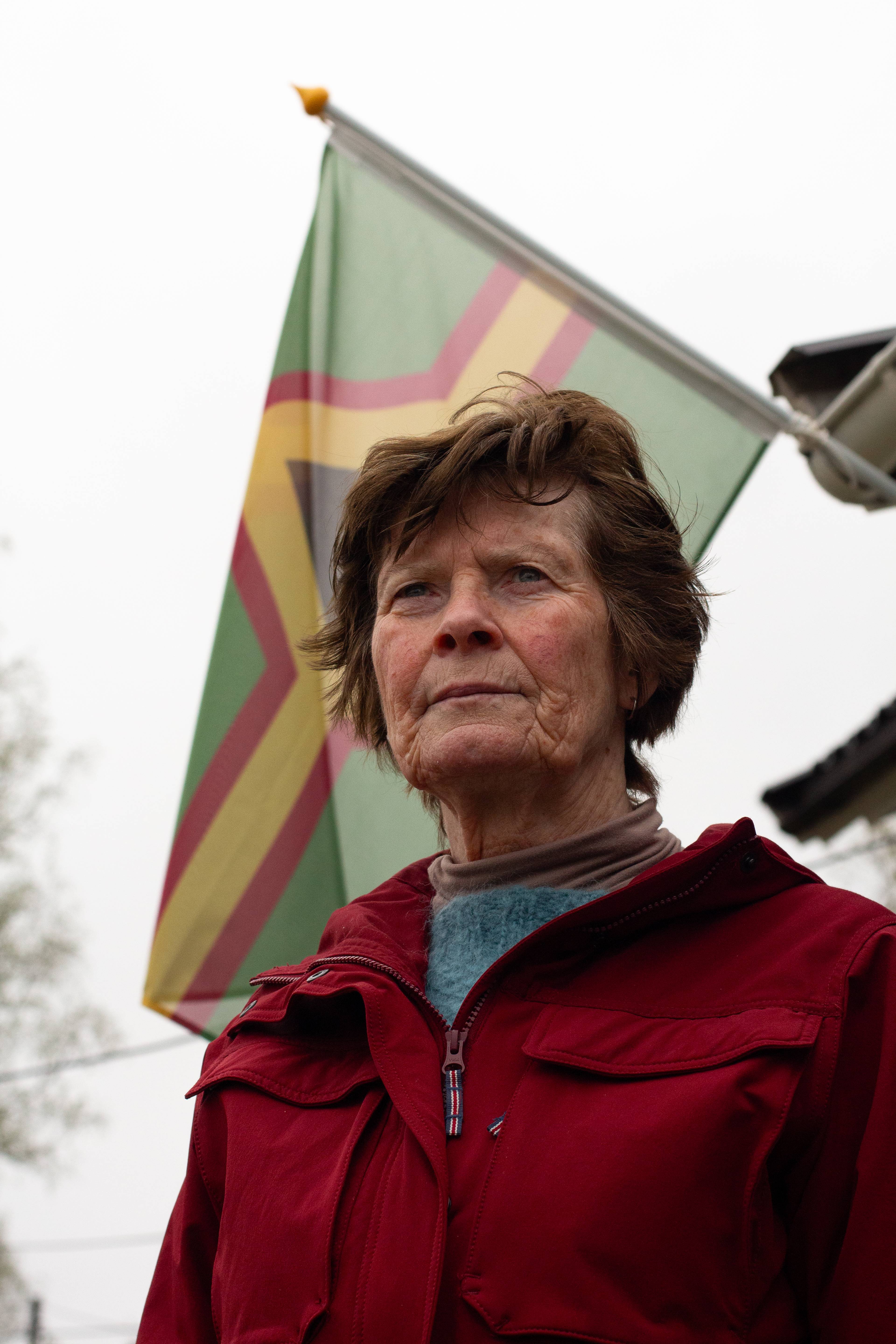 en kvinne står foran et flagg