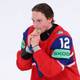 Reuters En ishockeyspiller i en rød drakt med nummer 12 biter på en gullmedalje. Spilleren har hendene rundt medaljen. Det er et hvitt bakteppe. (Bildebeskrivelsen er laget av en KI-tjeneste)