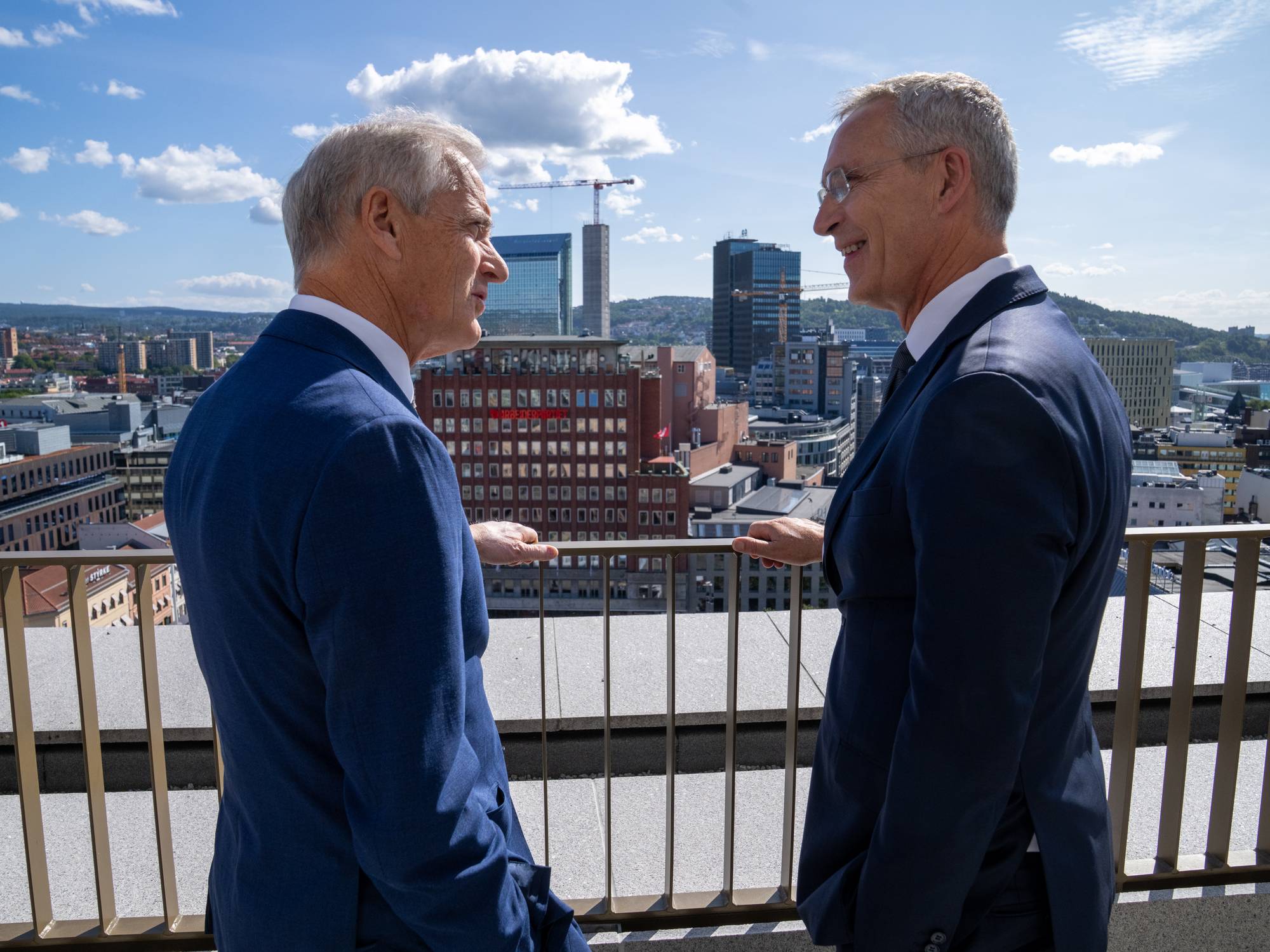 Finansminister Jens Stoltenberg og statsminister Jonas Gahr Støre intervjues før årets siste budsjettkonferanse på Statministerens kontor. Stills er tatt på forværelset til Statministerens nye kontor i D-blokka i det nye Regjeringskvartalet. Ellers er Stoltenberg og Støre på balkongen utenfor SMK. Stoltenberg viser Støre Arbeiderpartiets hovedkontor i Folketeaterbygningen på Youngstorvet, som skimtes i bakgrunnen.
