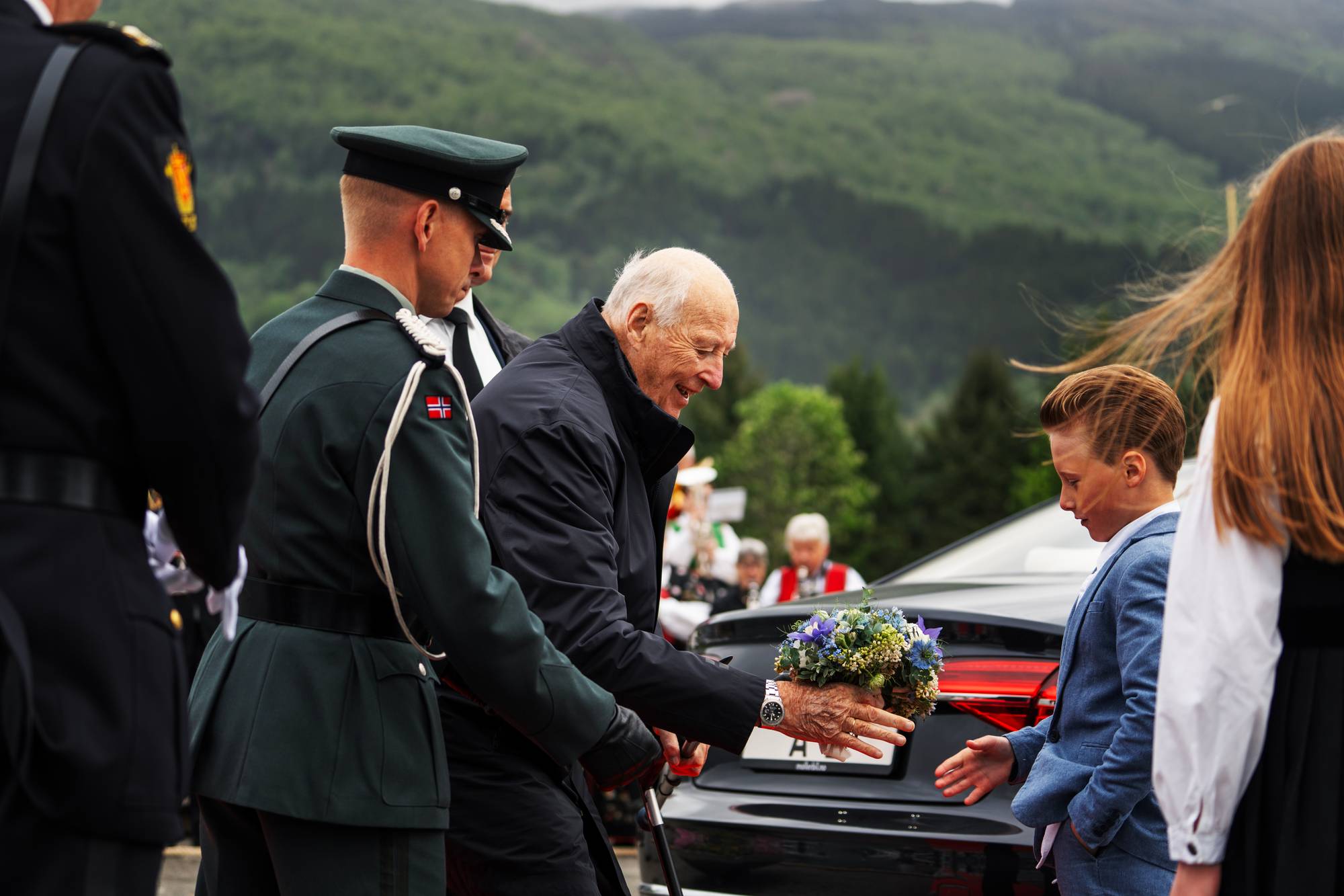 Kong Harald blir tatt imot av en gutt med blomster når han går i land i Etne kommune på første dag av fylkesturen i Vestland i mai 2026