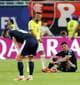 Paul Childs / REUTERS,NTB Fotballspilleren Neymar i gul drakt med nummer 10 står på en gressbane. To spillere i mørke drakter sitter eller bøyer seg ned. Det er en banner med "QATAR" i bakgrunnen. (Bildebeskrivelsen er laget av en KI-tjeneste)