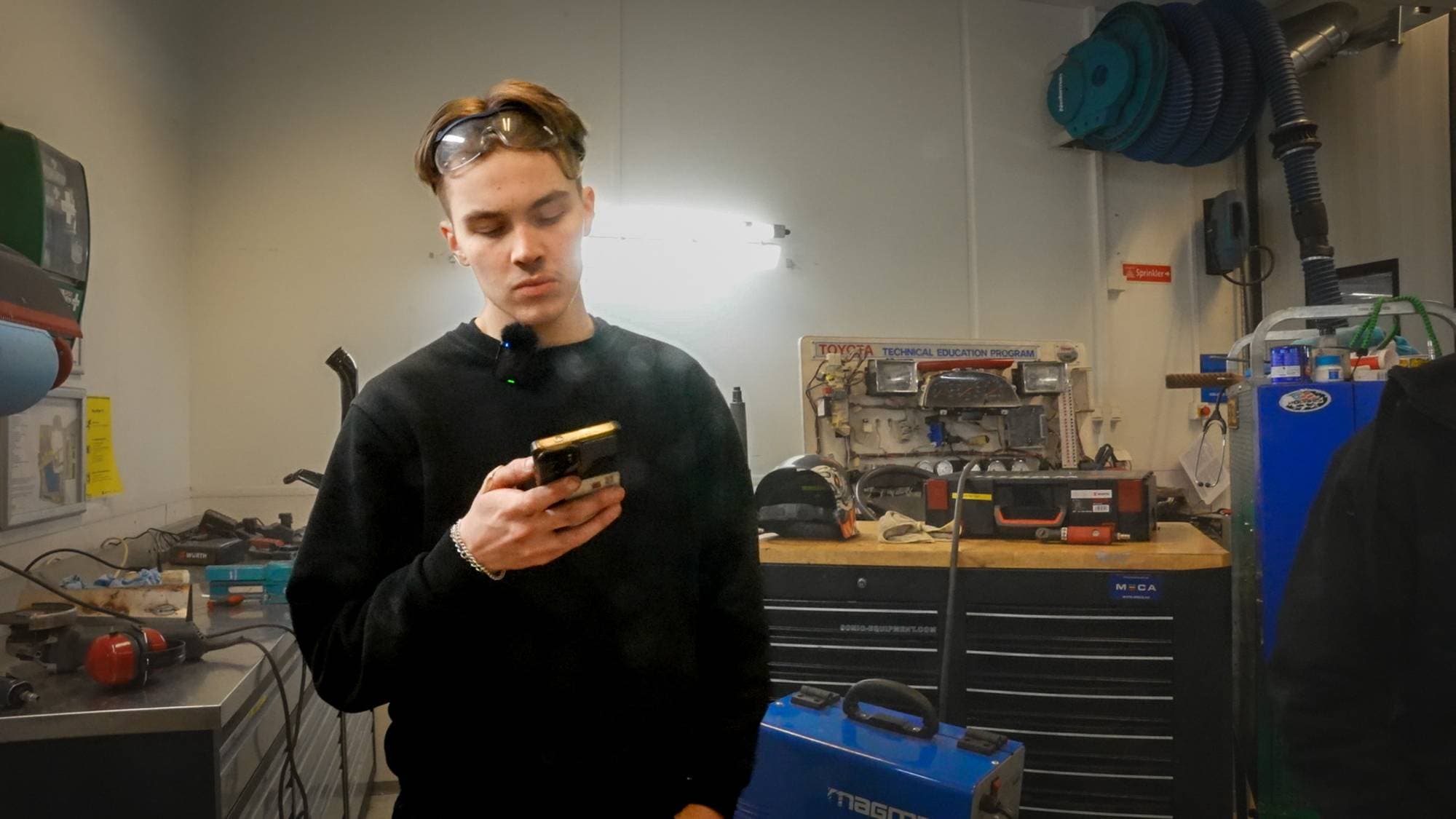 Ung mann sveiser og mekker på bil