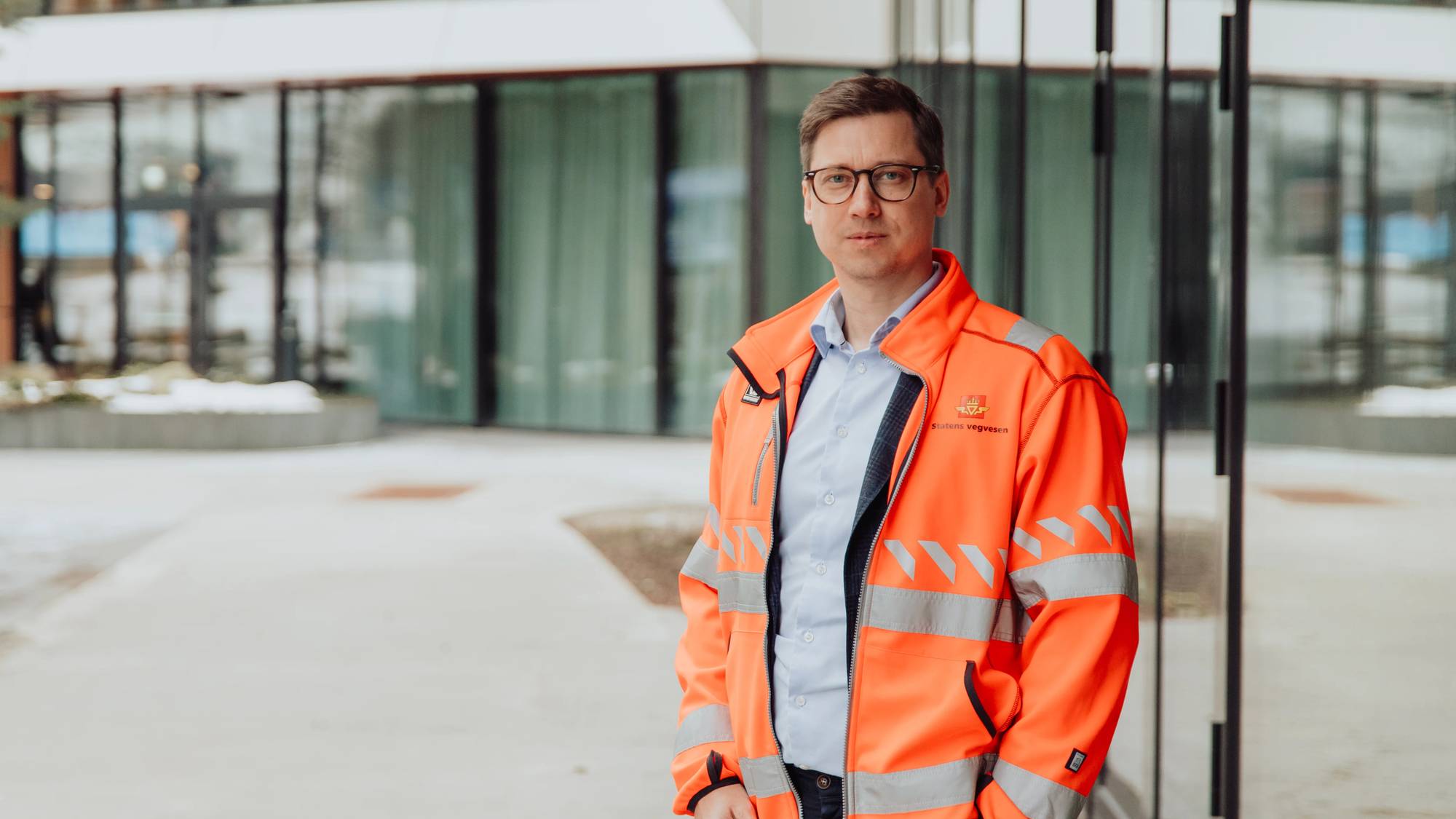 Portrettbilde av Erlend Aakre, divisjonsdirektør i statens vegvesen, iført en stor oransje jakke