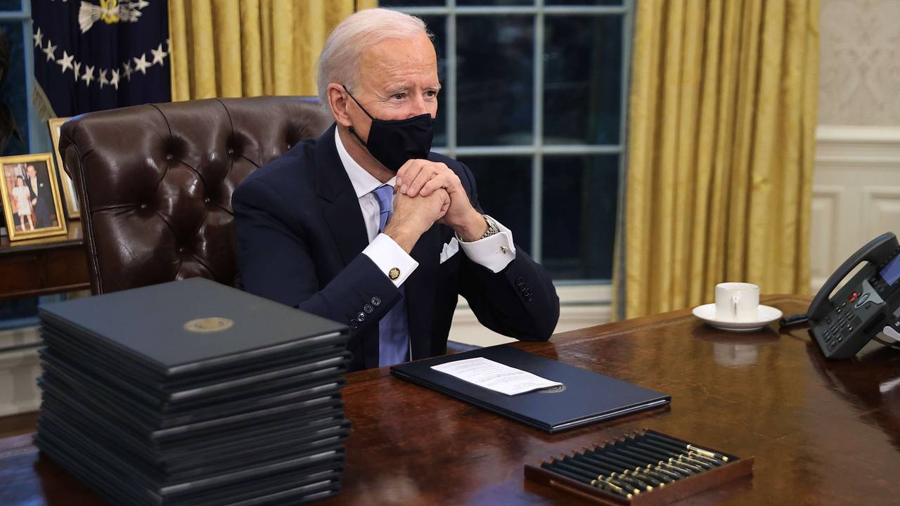 Joe Biden ved pulten med de mange pennene i Det hvite hus.