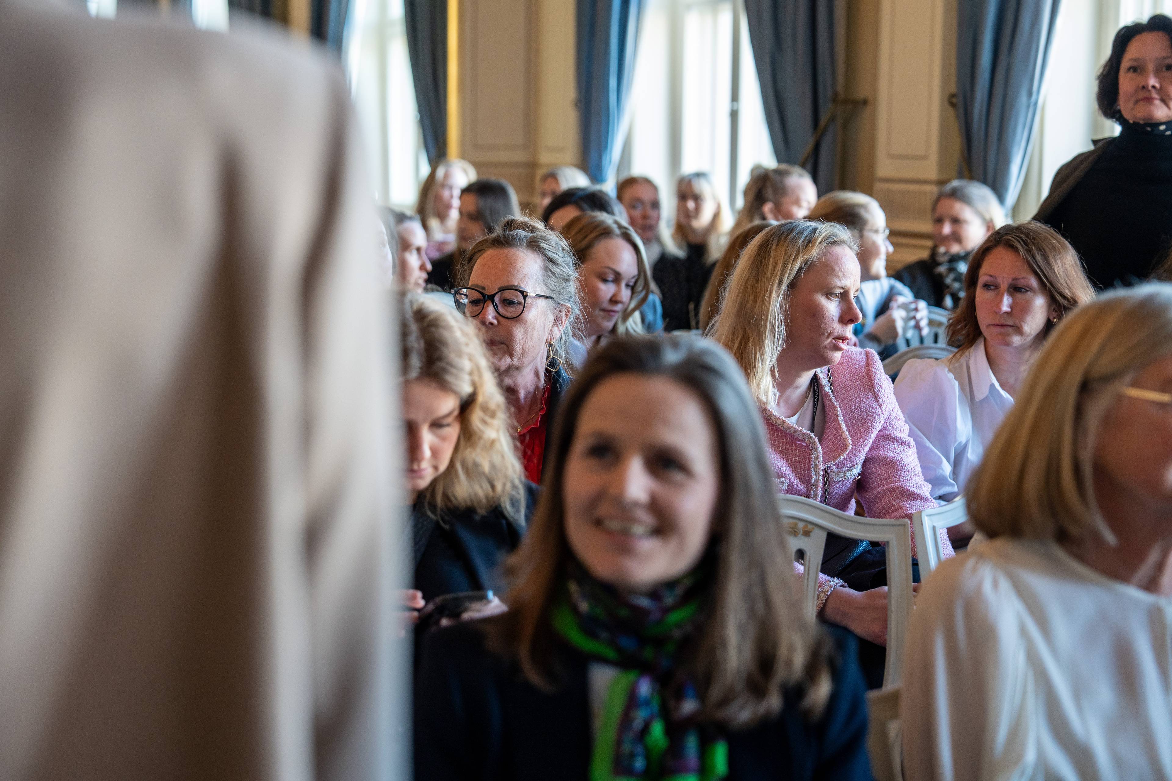 Mange kvinner sitter i en sal