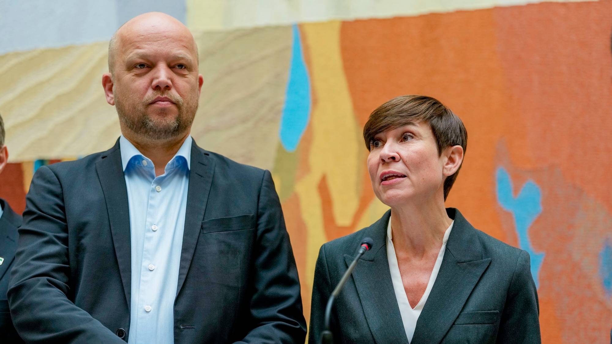 Trygve Slagsvold Vedum og Ine Eriksen Søreide står sammen ved en talerstol. (Bildebeskrivelsen er laget av en KI-tjeneste)