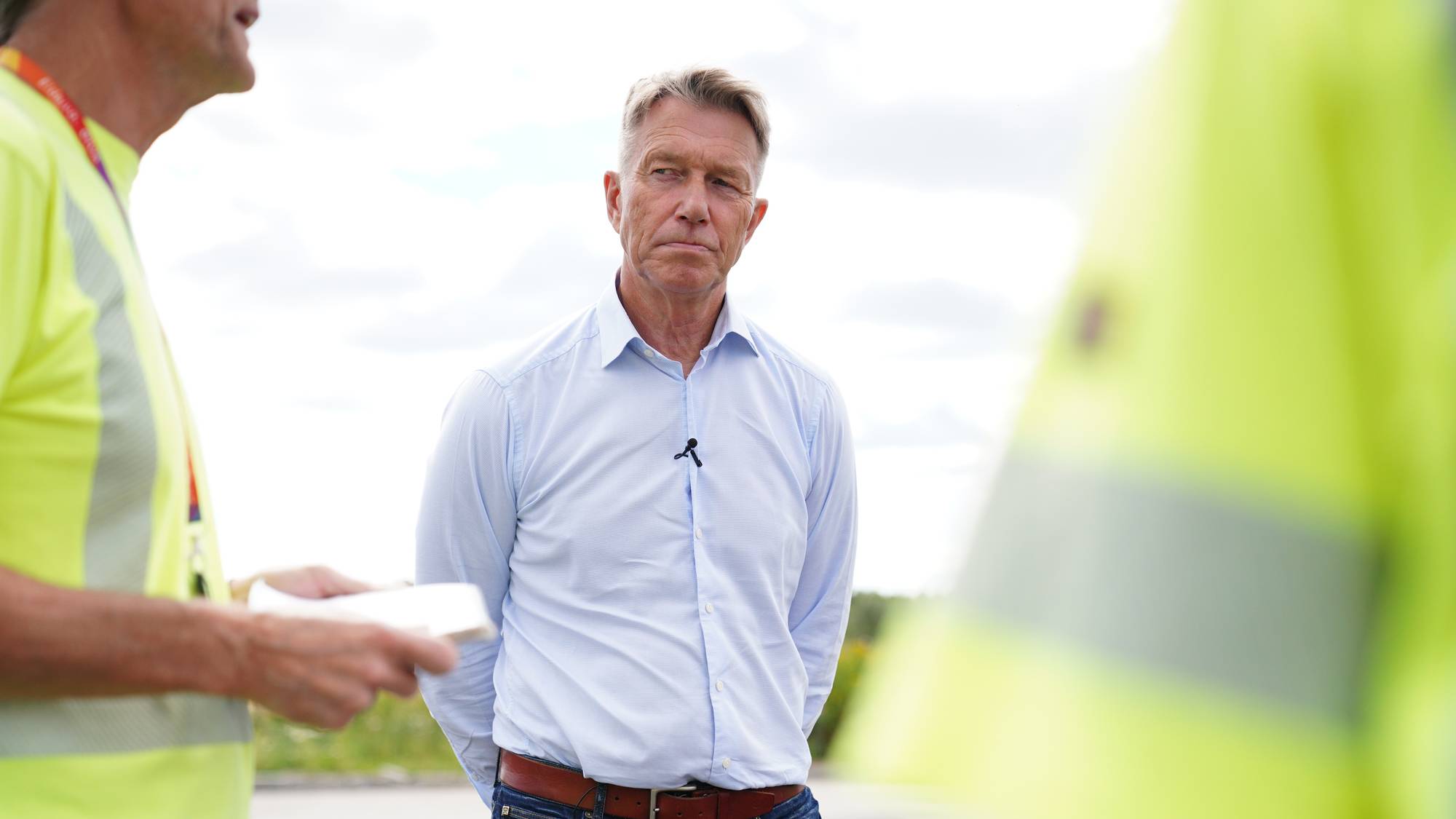 Terje Aasland ser på mann i gul vest