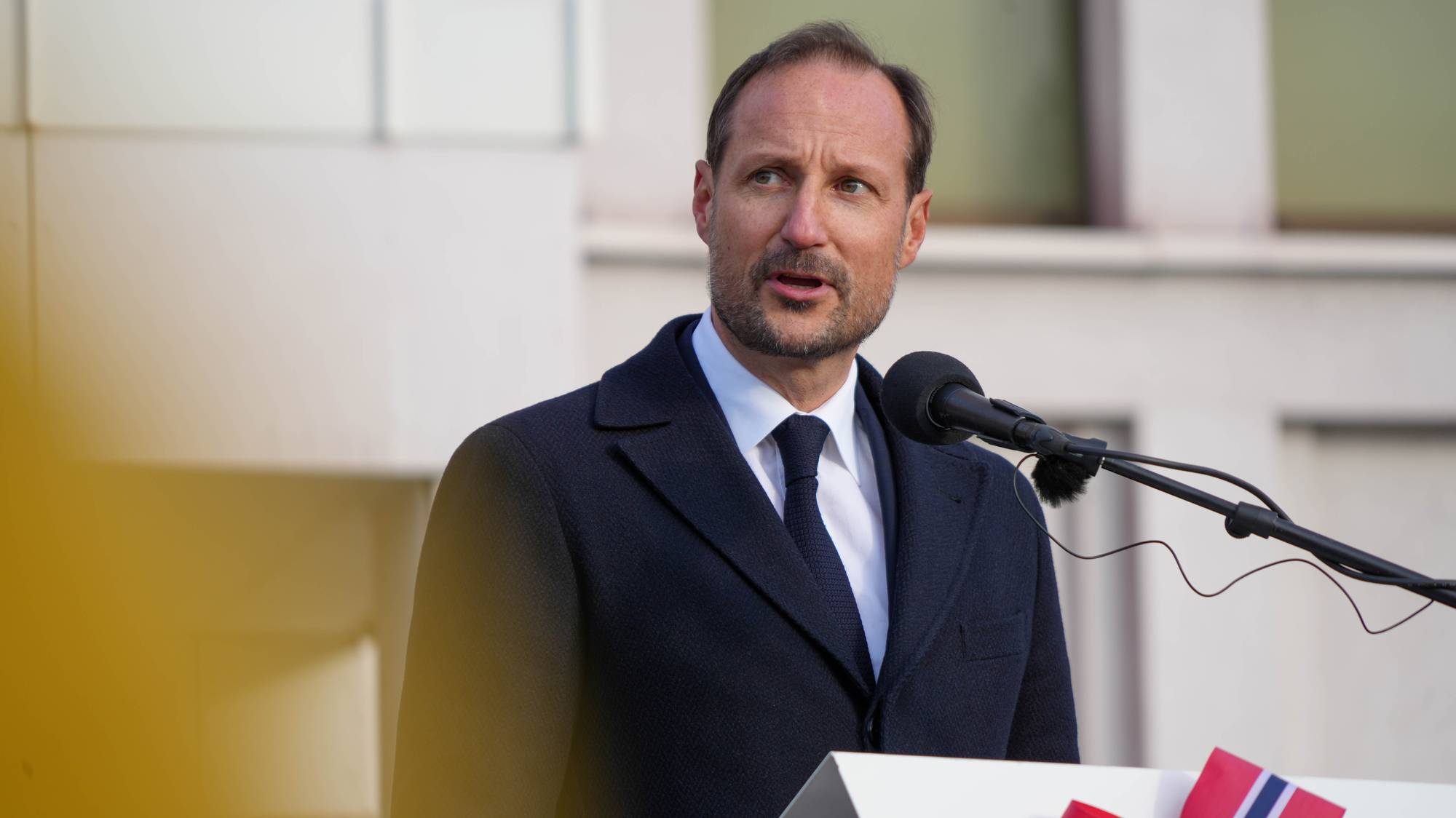 Kong Haakon står på en talerstol og snakker inn i en mikrofon