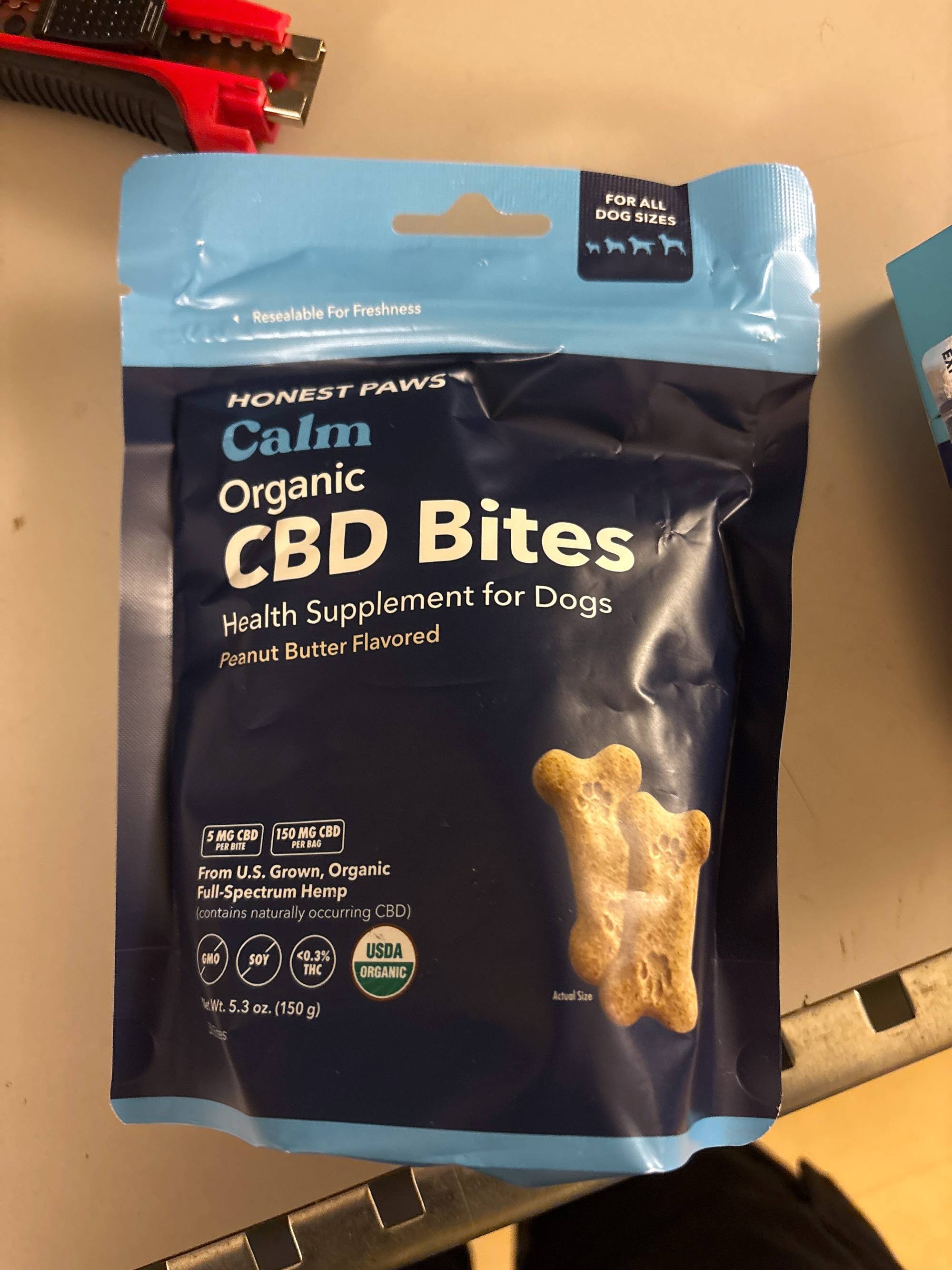 Pose med Honest Paws CBD-godbiter for hunder med peanøttsmak. (Bildebeskrivelsen er laget av en KI-tjeneste)