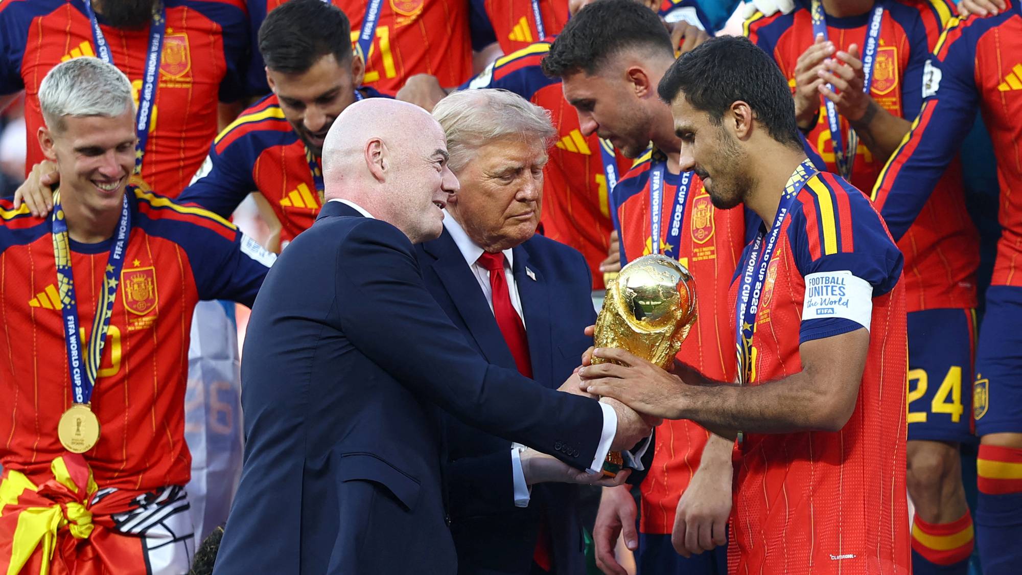 Gianni Infantino og Donald Trump overrekker VM-trofeet til en spansk landslagsspiller i fotball. (Bildebeskrivelsen er laget av en KI-tjeneste)