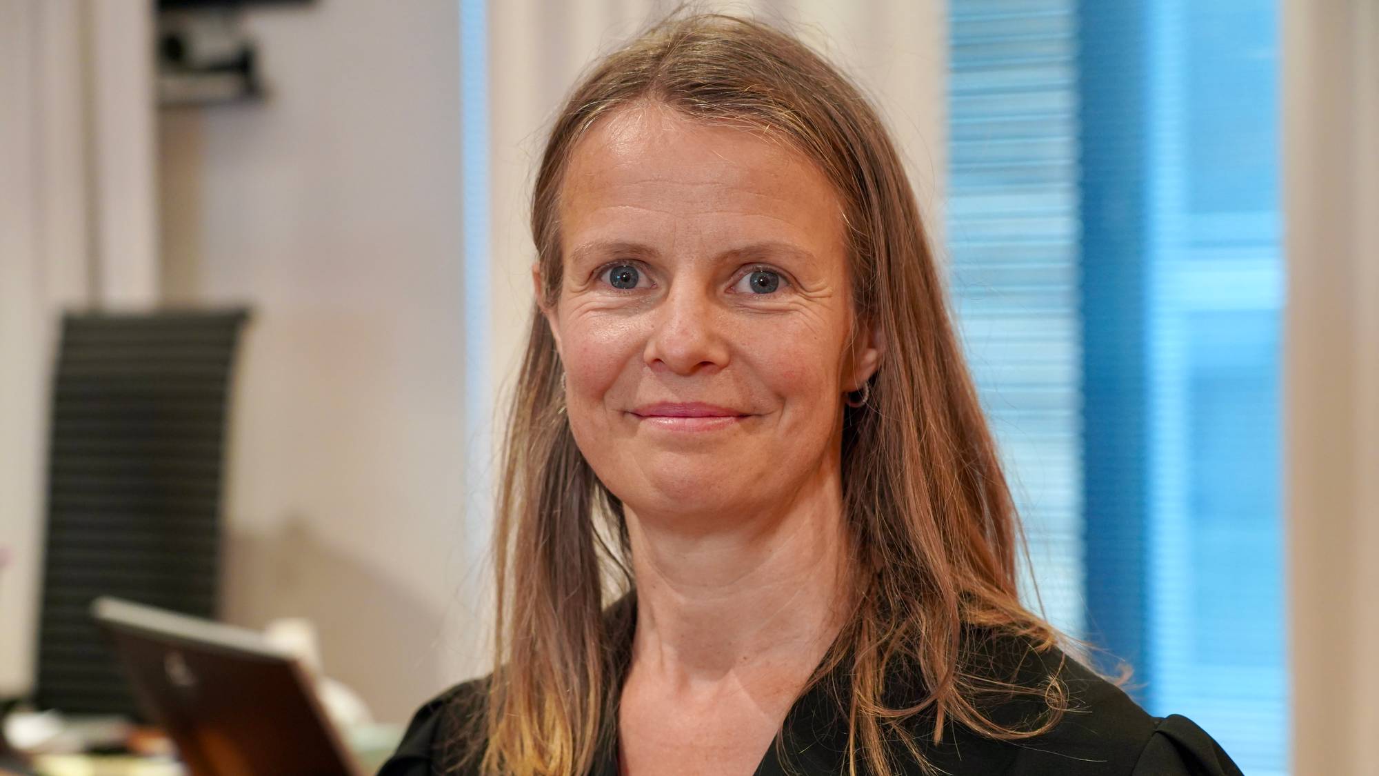 Portrett av en kvinne i dommerkappe i en rettssal. (Bildebeskrivelsen er laget av en KI-tjeneste)