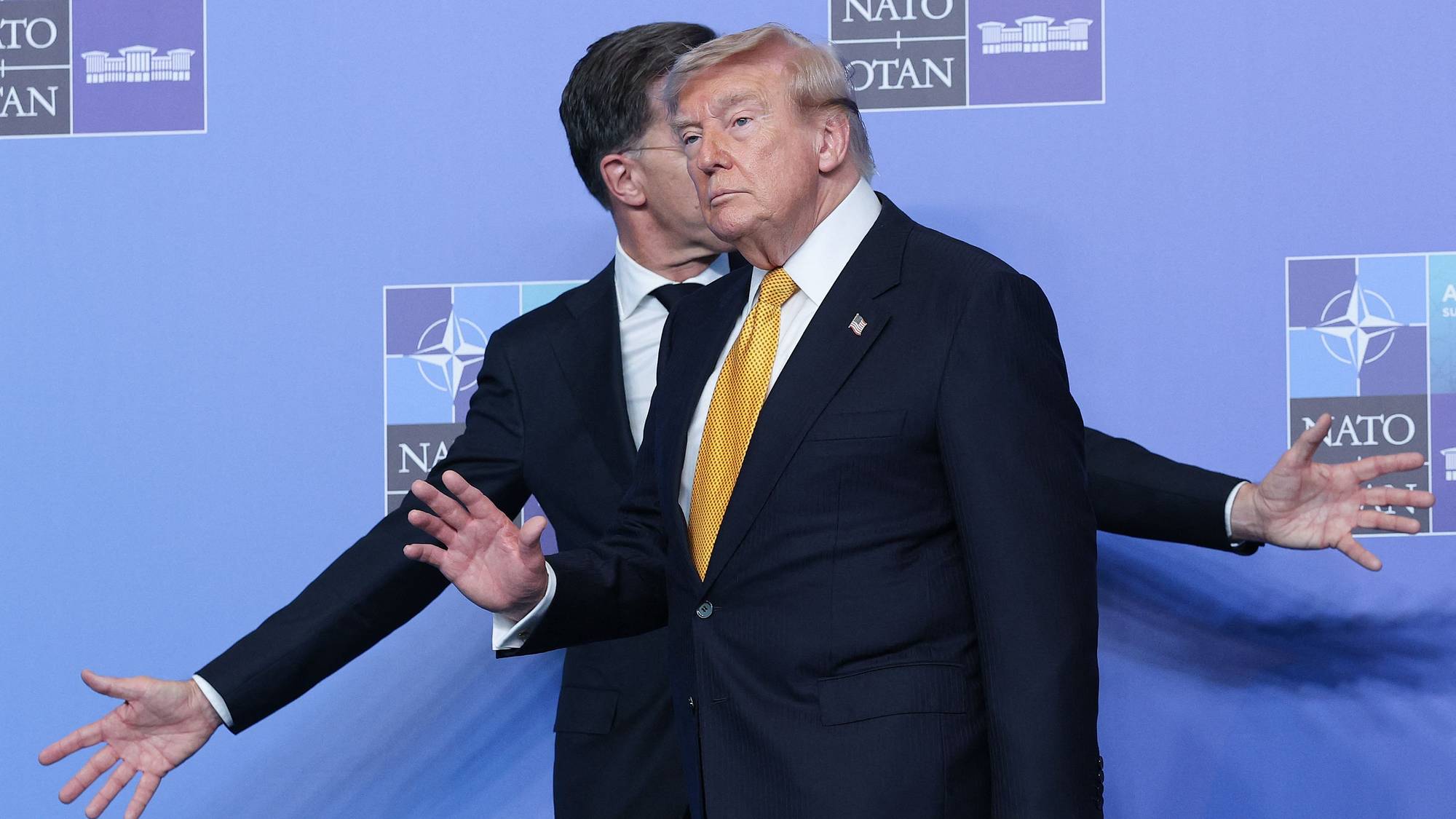 Donald Trump står foran Mark Rutte med en NATO-bakgrunn. 