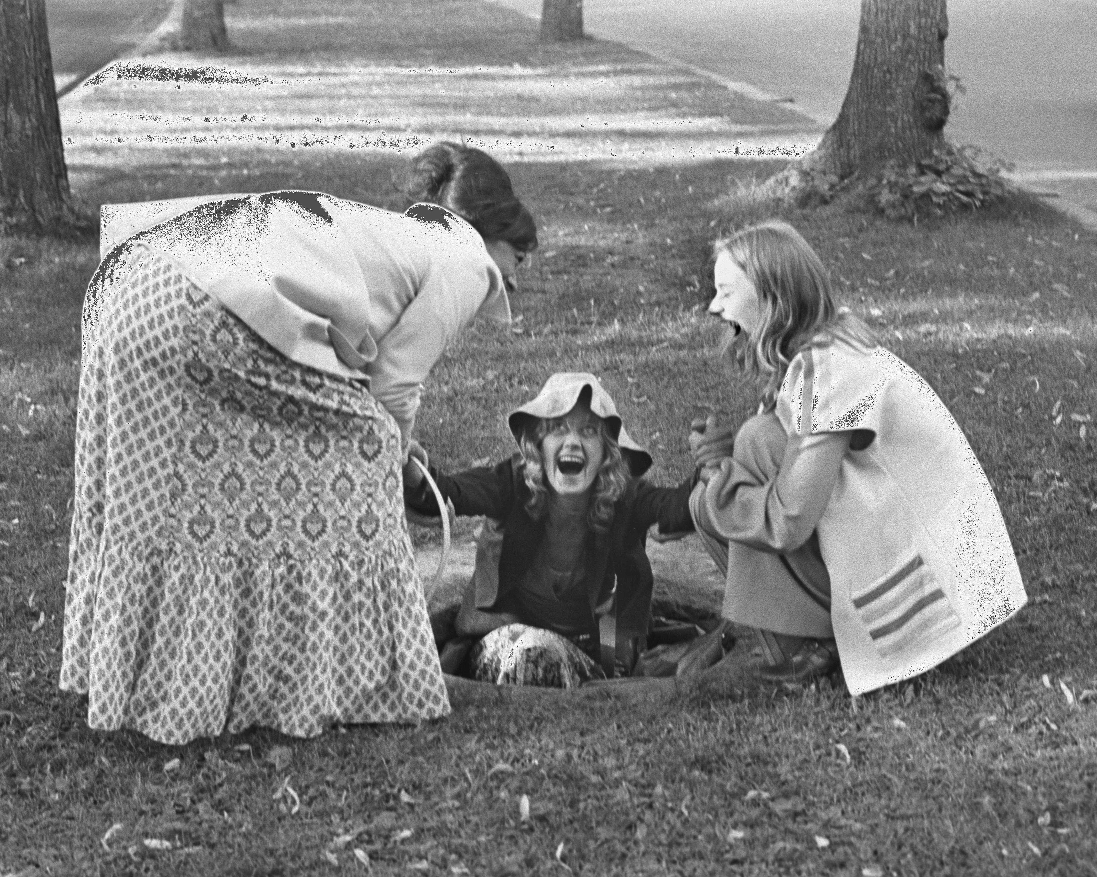 Oslo 19740810. Filminnspilling av filmen Hustruer ved filmregissør Anja Breien. Filmen handler om tre gifte kvinner som forlater mann og barn i tre døgn og går på rangel. Temaet er kvinnenes frigjøring. På bildet Anne-Marie Ottersen (t.h.) og Katja Medbøe drar opp Frøydis Armand av jordhullet. Foto: Aage Storløkken Aktuell / Scanpix