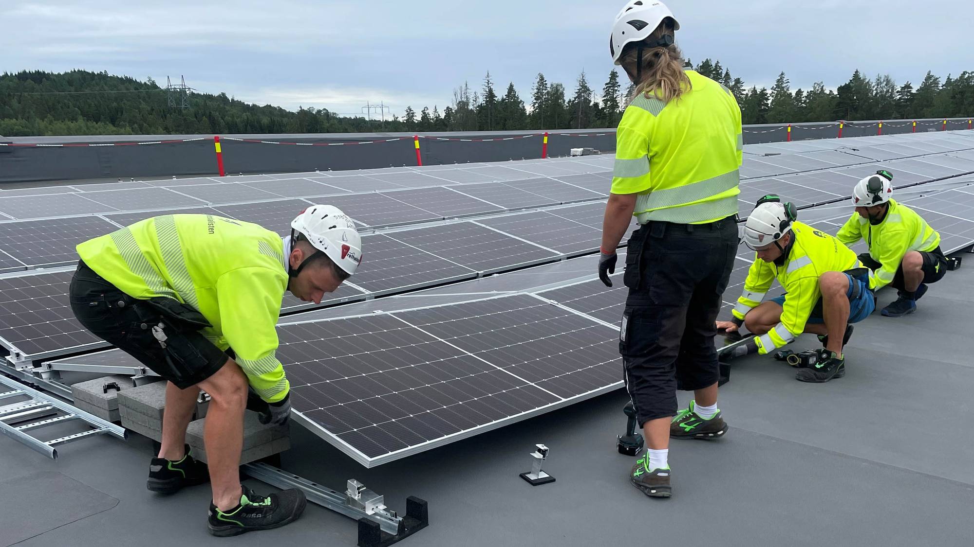 Montører fester solcellepanel på tak 