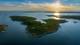 Foto: Privatmegleren En øy i skjærgård med solnedgang