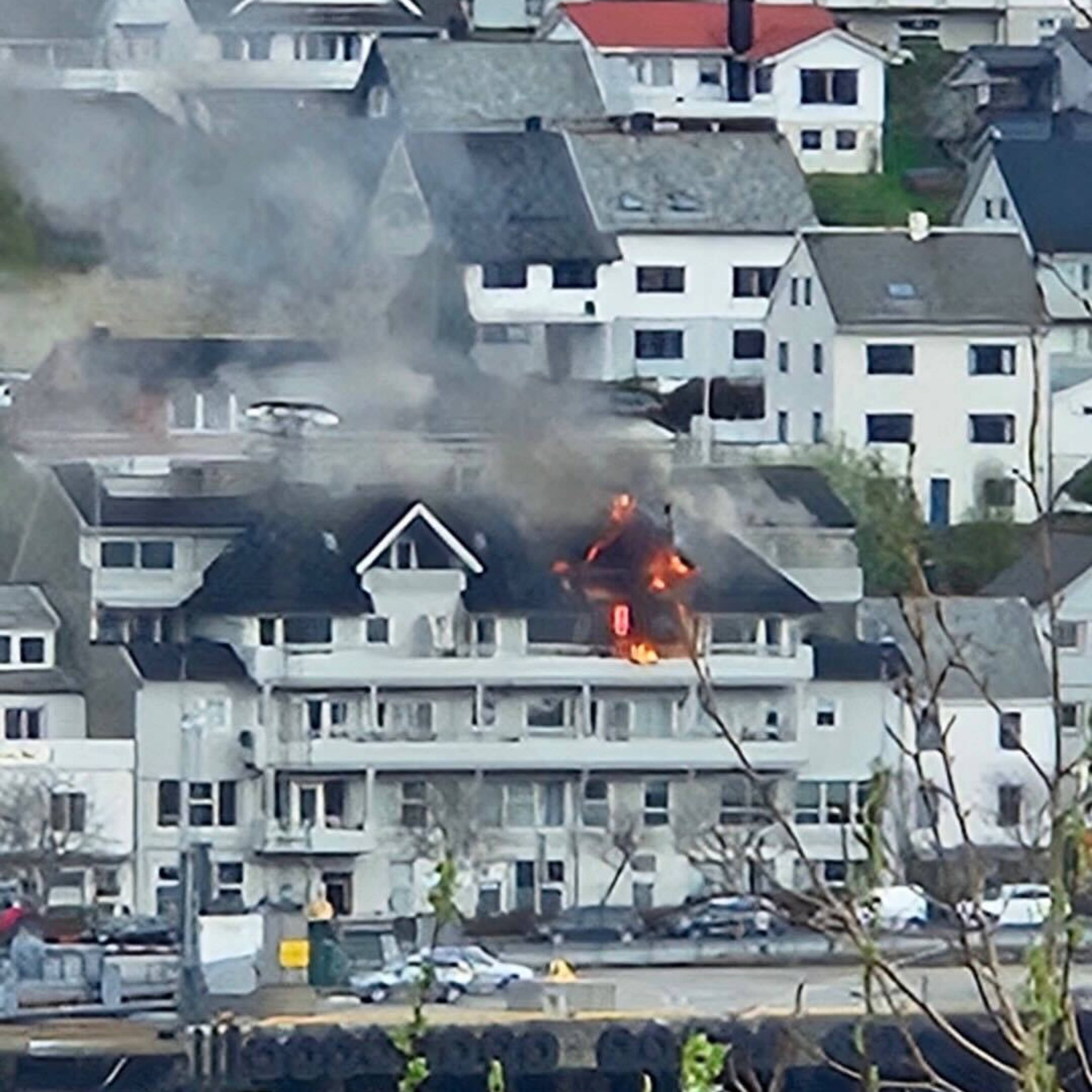 brann og røyk stig opp frå eit leilighetsbygg i eit bustadfelt