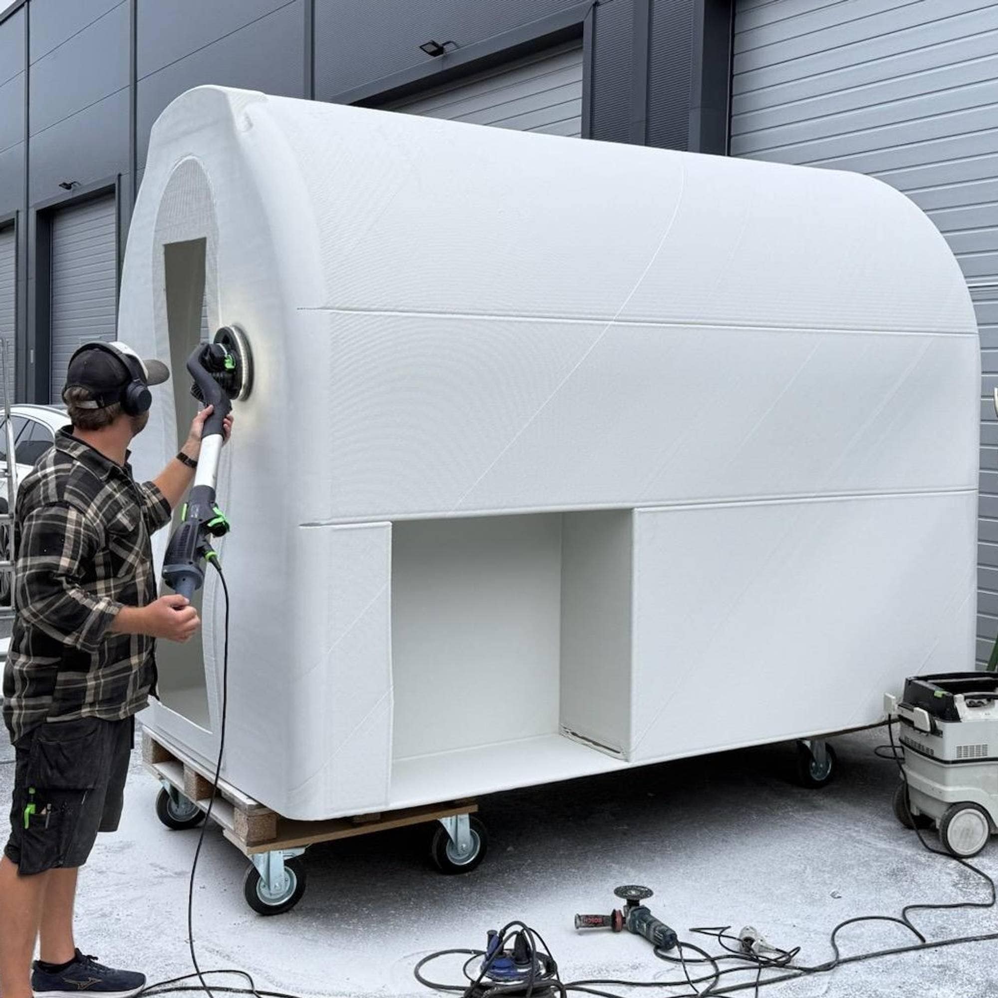 Hvit isvogn pusses og klaregjøres etter 3D-printing.