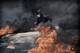 Photo: Harald Henden / VG Gaza, 2018: A Palestinian youth throws rocks at the Israeli border fence. The air is filled with black smoke from burning tires.