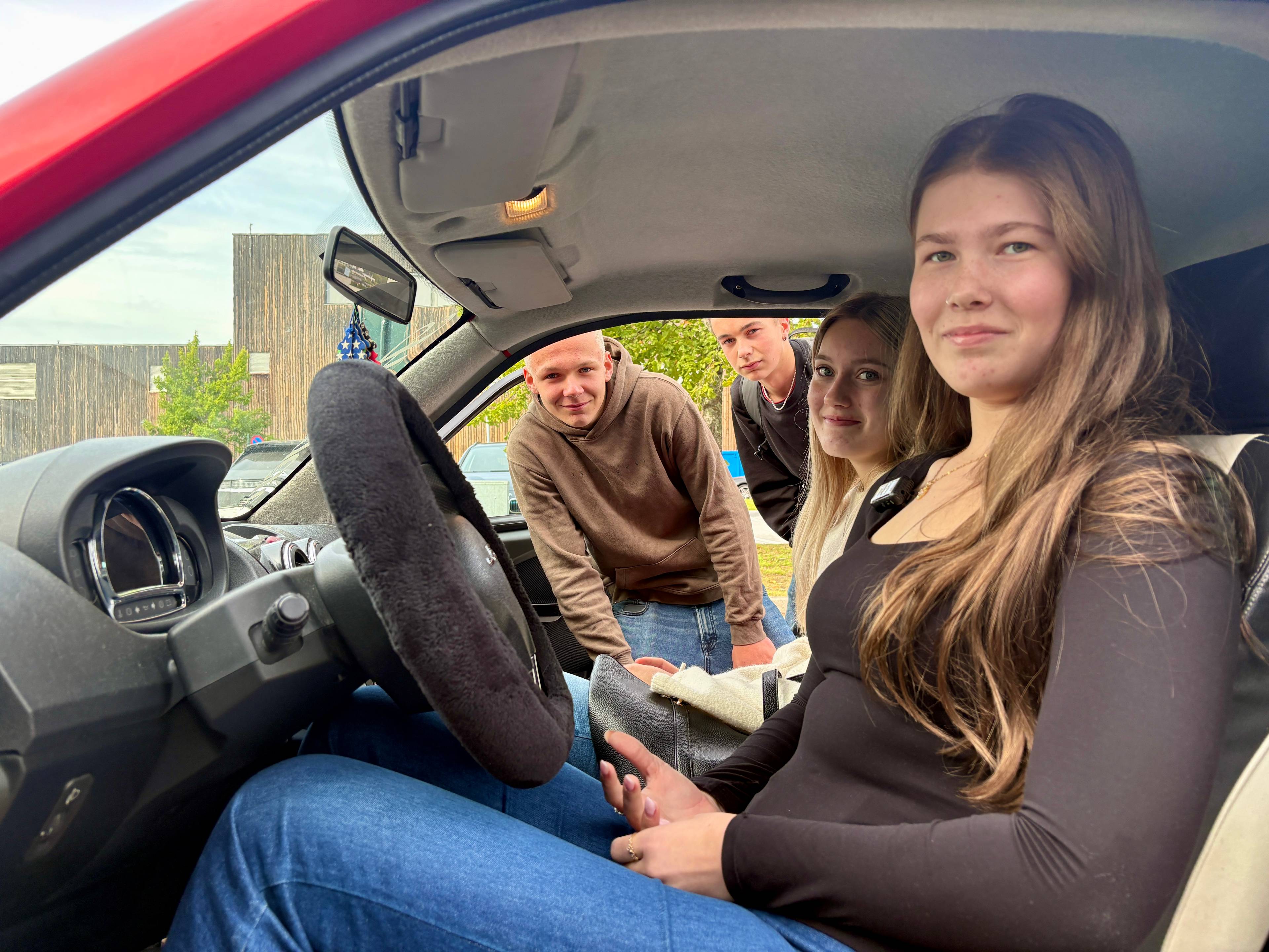 Jenter bak rattet på en mopedbil.